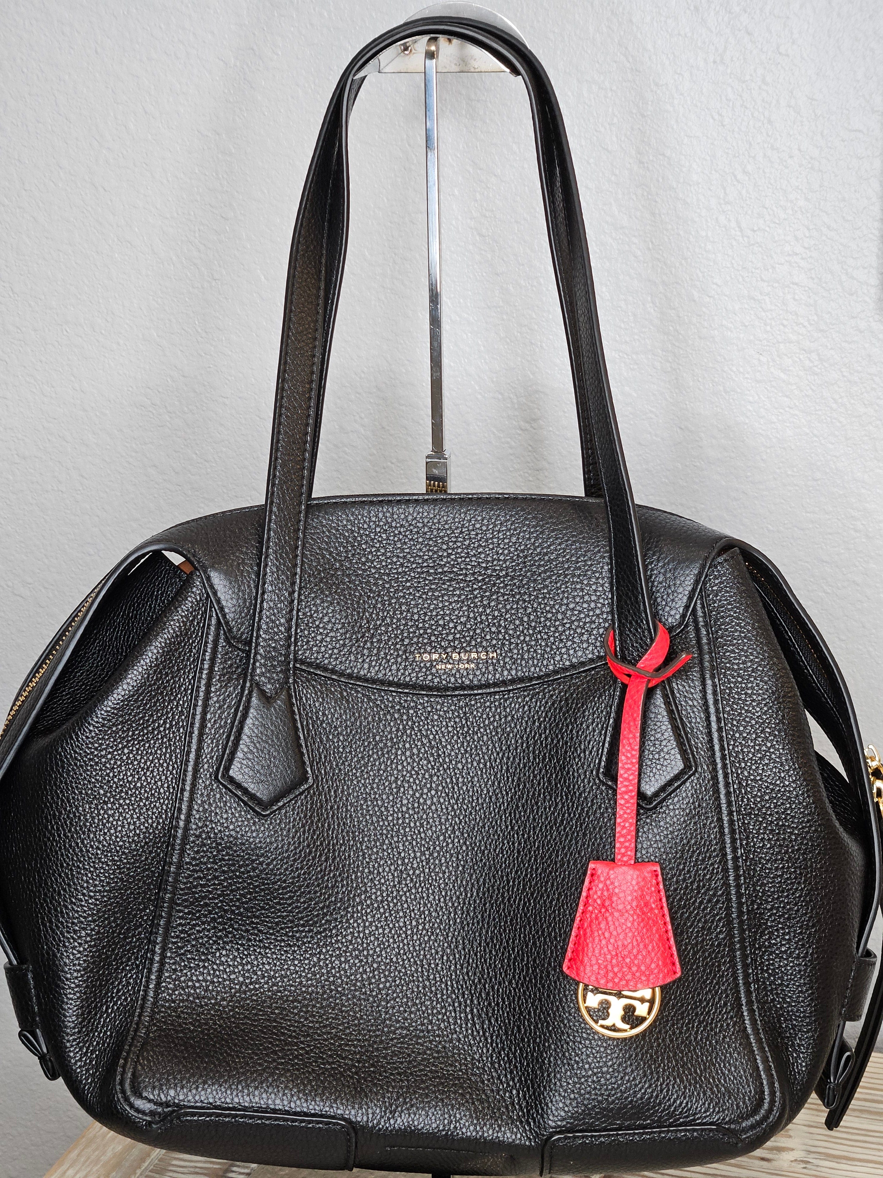 Black leather bag with a red tag on a light gray background