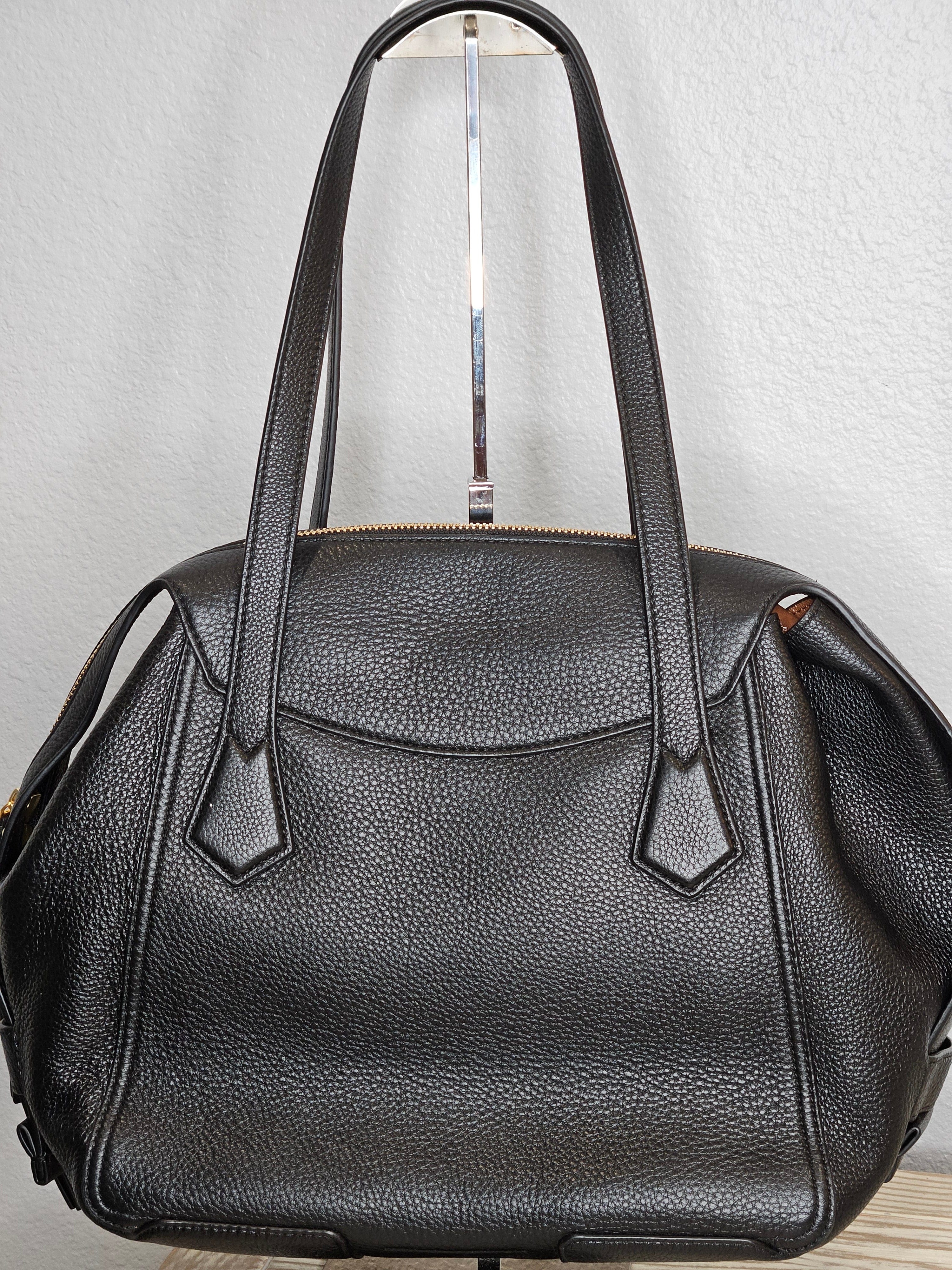 Black leather bag with a handle on a light gray background