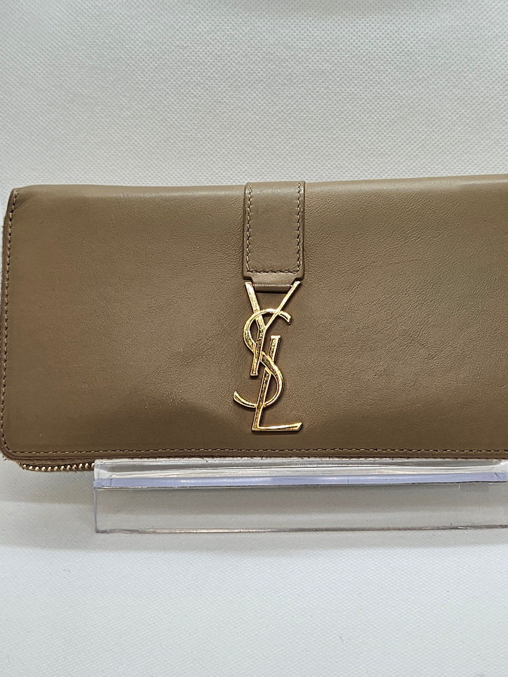 Beige wallet with gold logo on a light gray background
