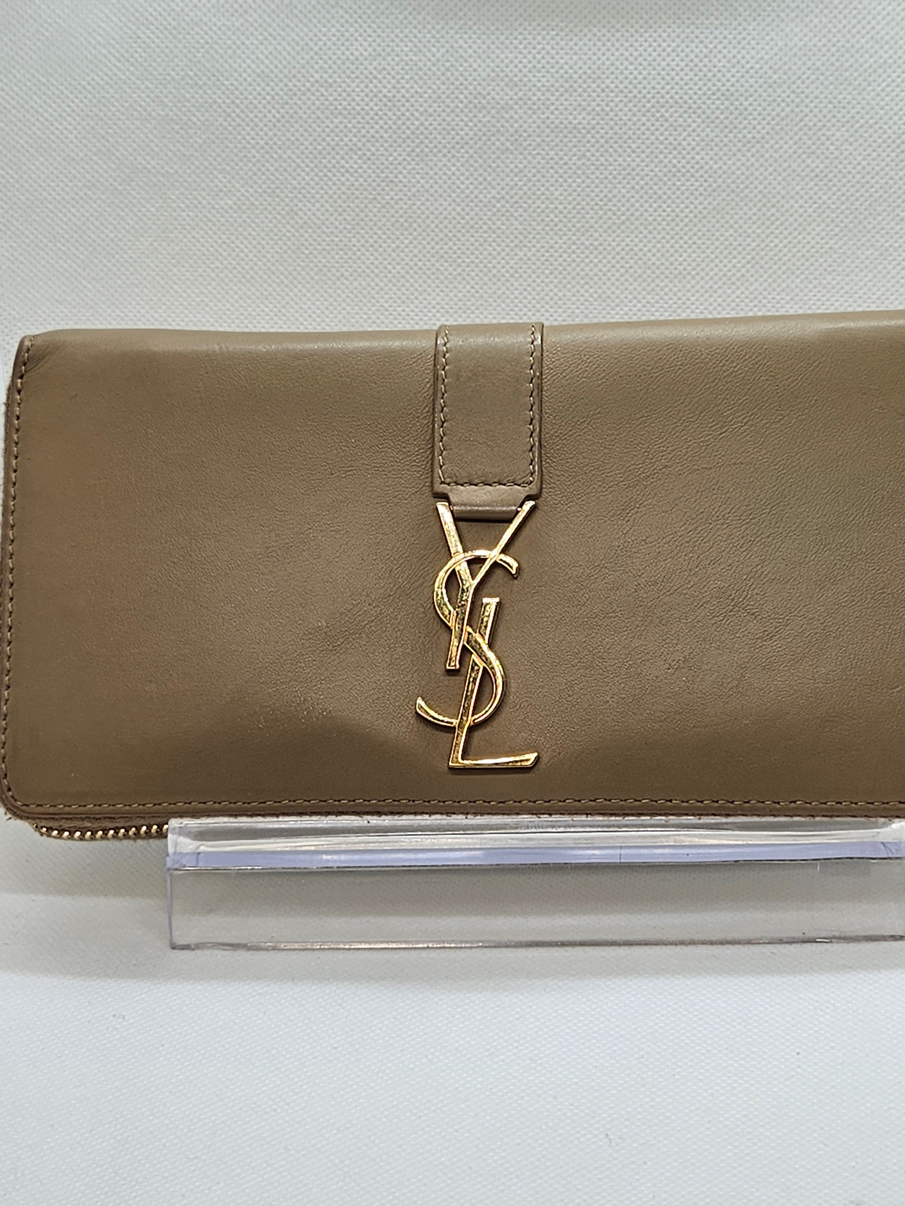 Beige wallet with gold logo on a light gray background