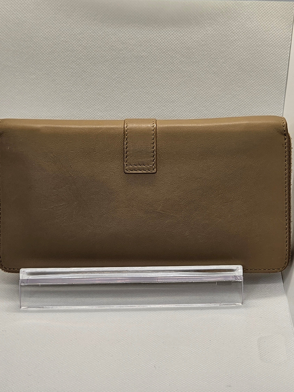 Brown wallet on a clear stand against a light gray background