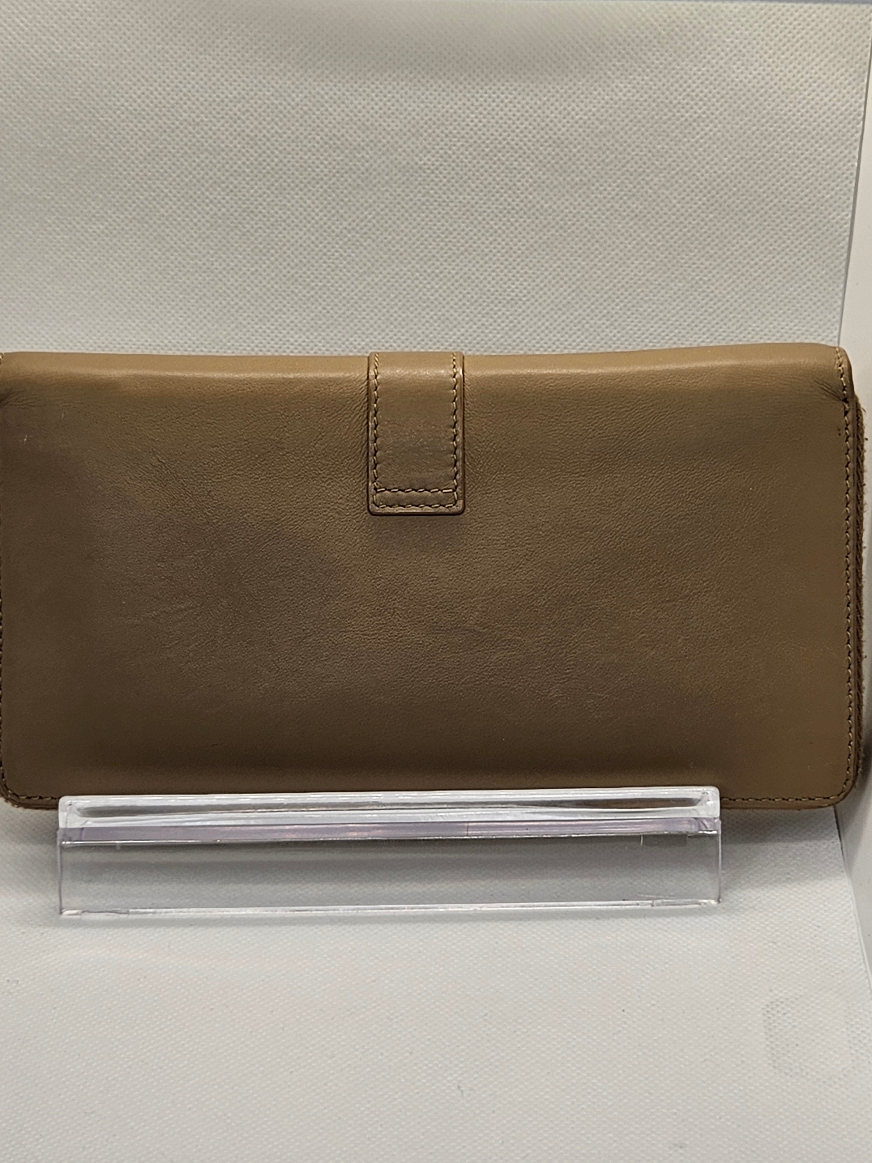 Brown wallet on a clear stand against a light gray background