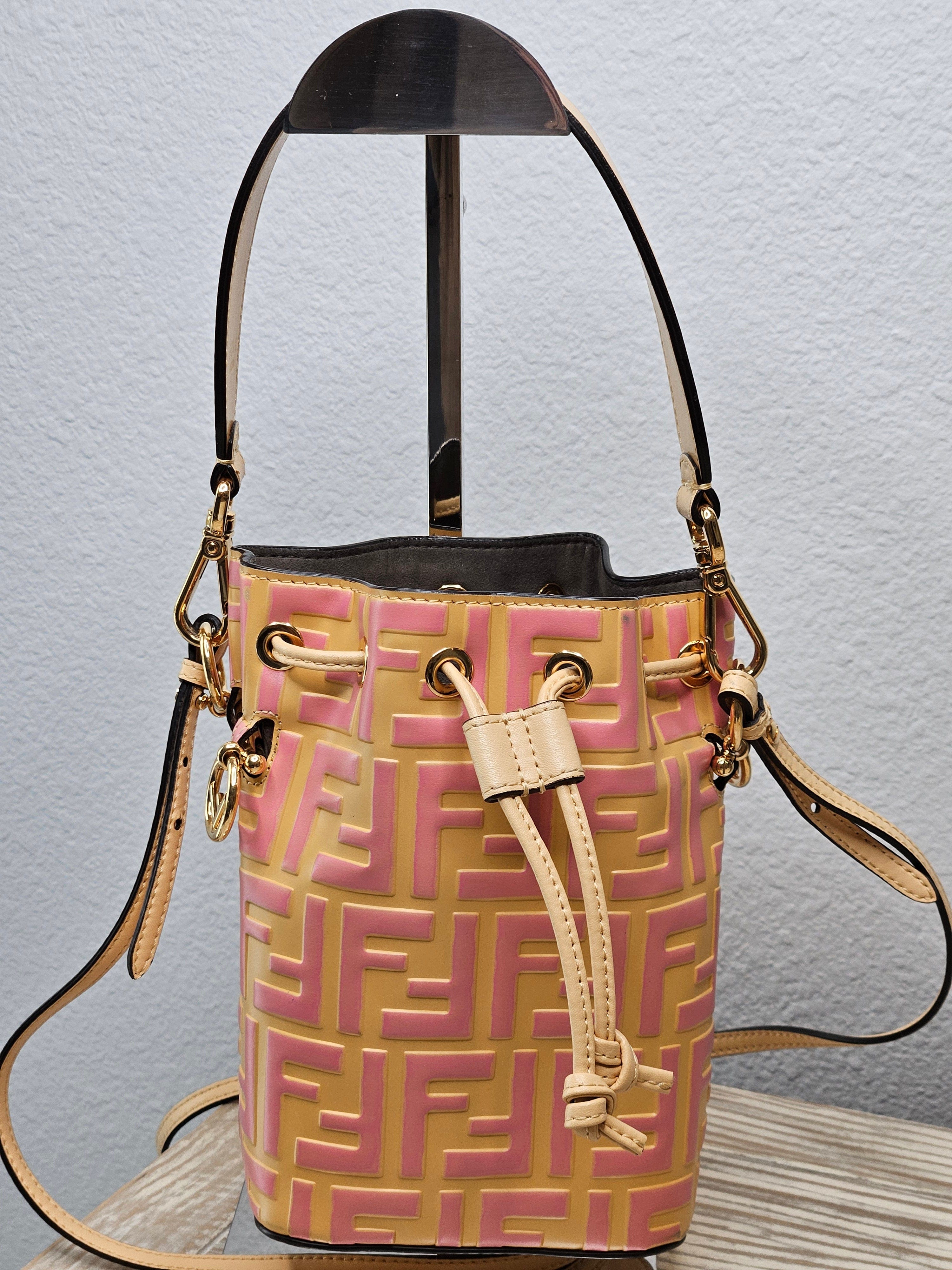A pre-loved Fendi Vitello Liberty Mini Mon Tresor Bucket Bag in beige, pink, and yellow with gold hardware, featuring a FF monogram-embossed leather design and a removable shoulder strap.
