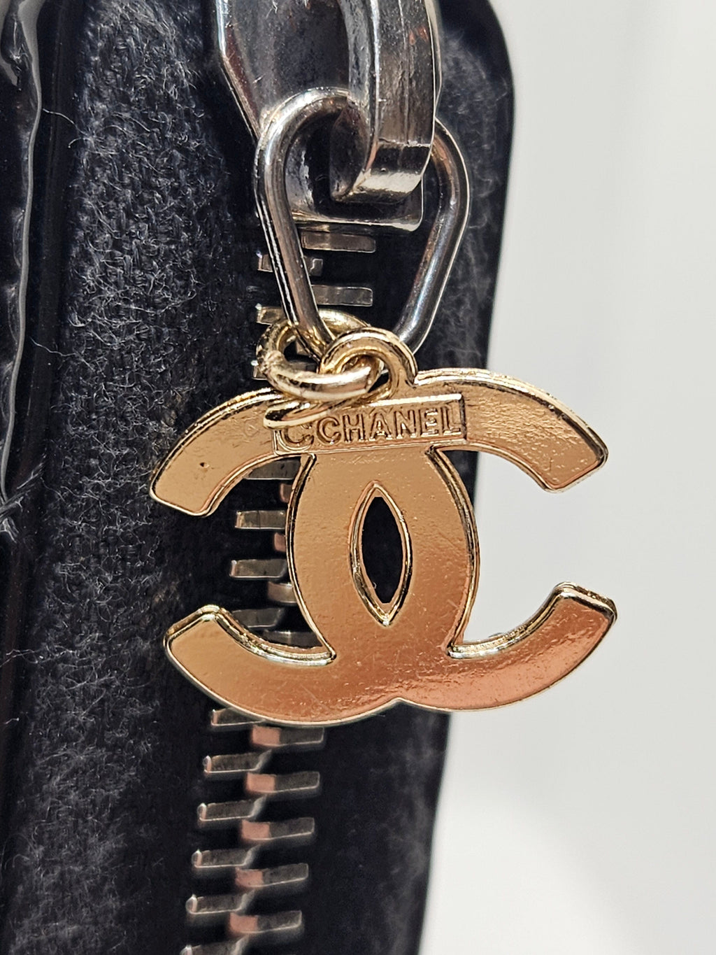 Gold and silver keychain attached to a black leather bag