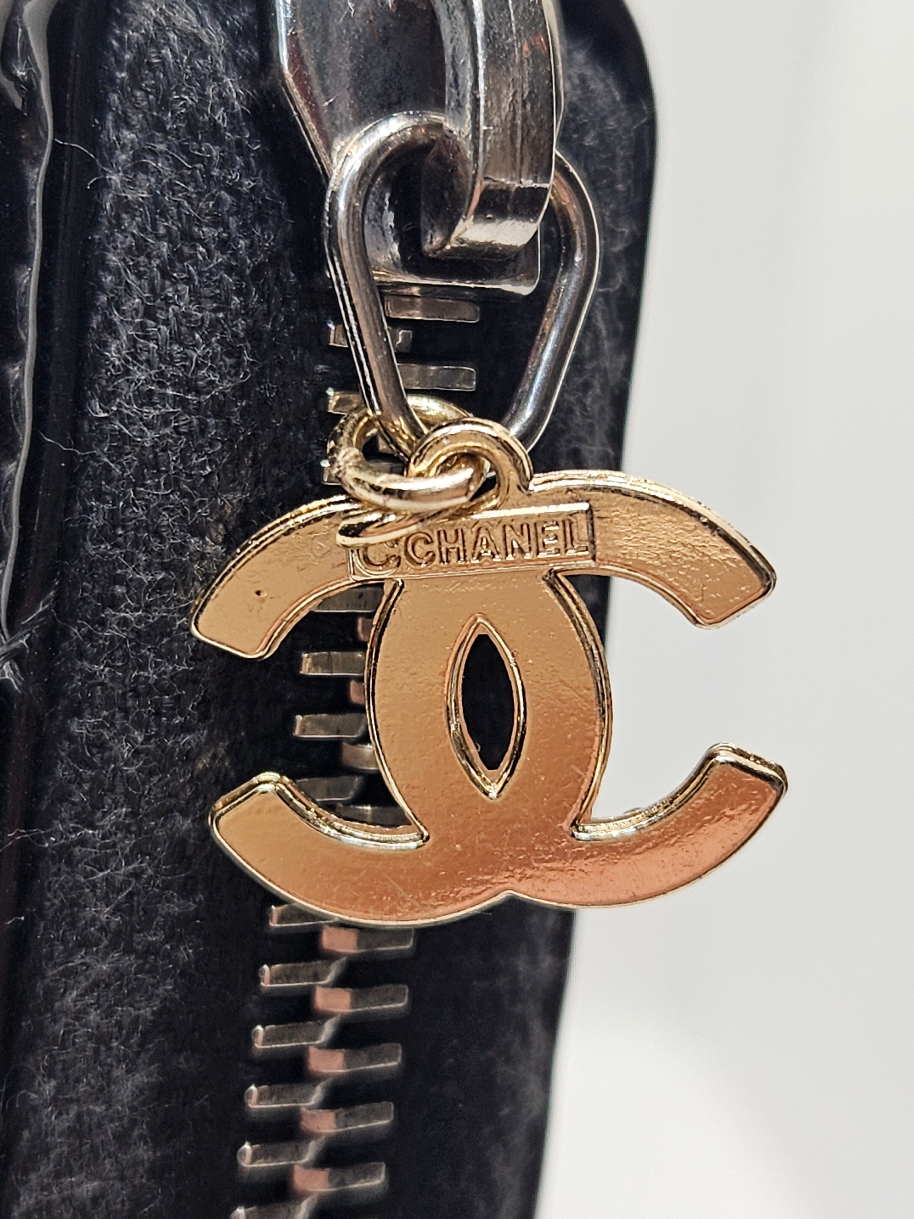 Gold and silver keychain attached to a black leather bag