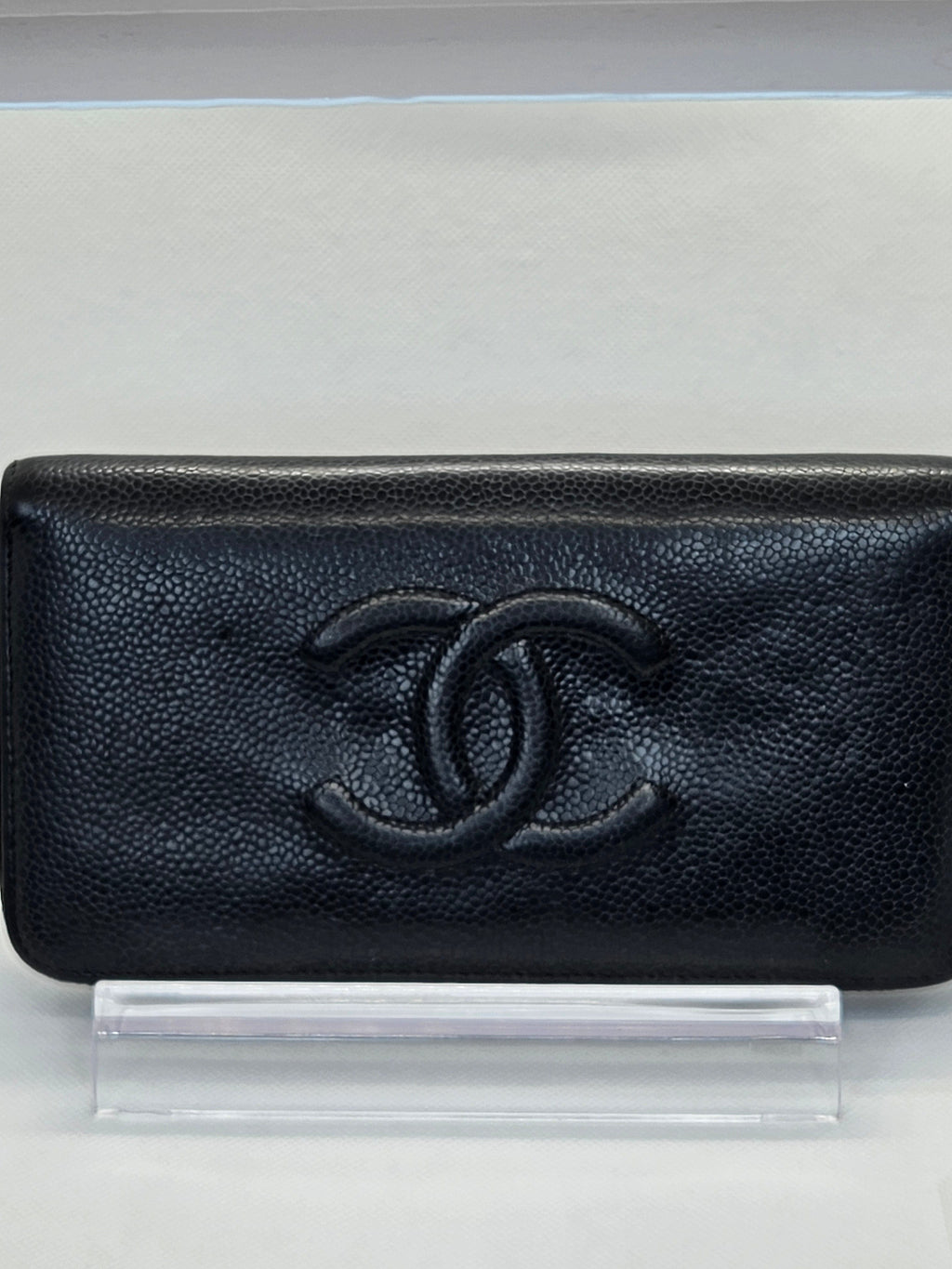 Black textured wallet with a brand logo on a white background