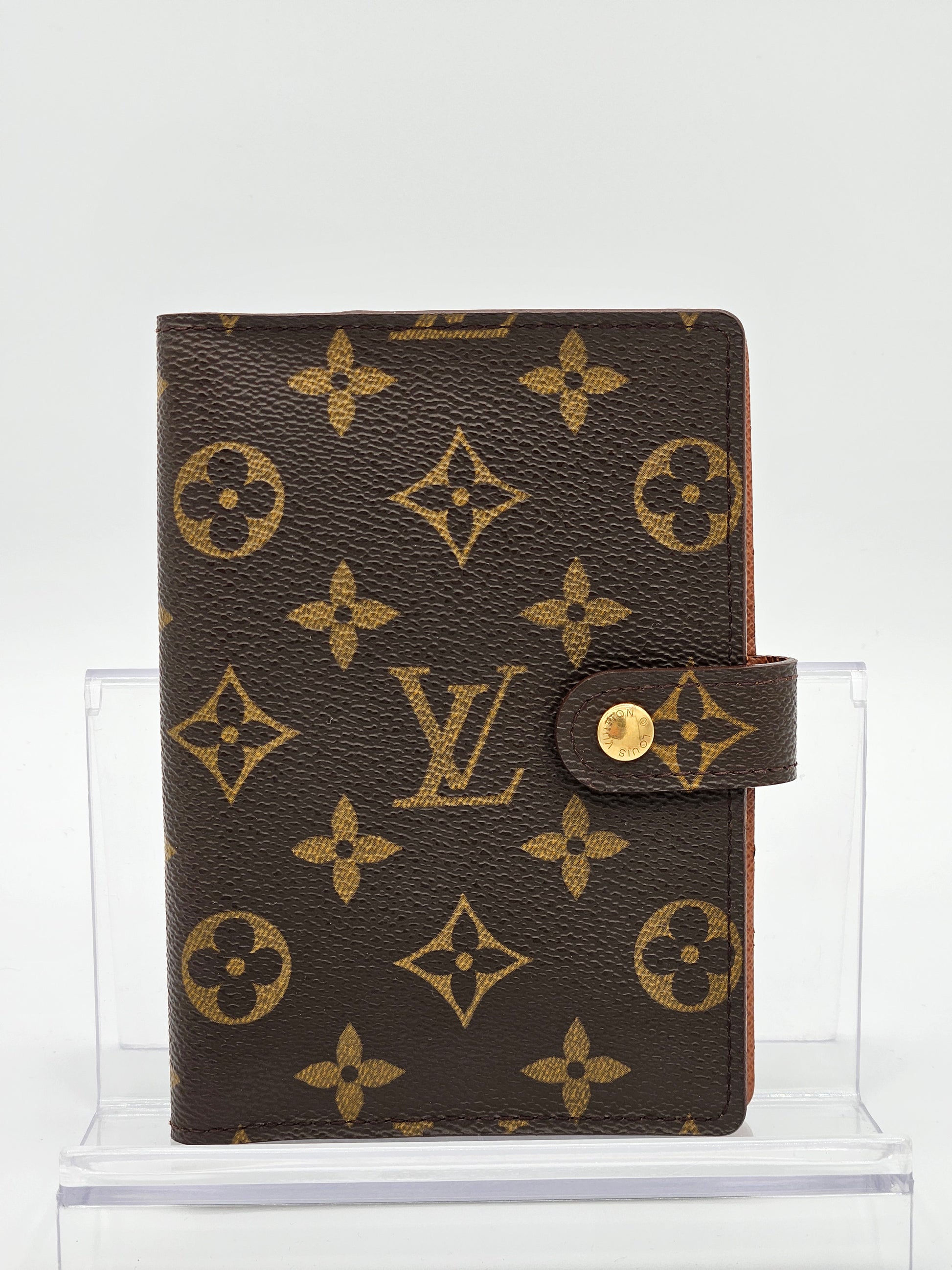 Louis Vuitton wallet with monogram pattern on a white background