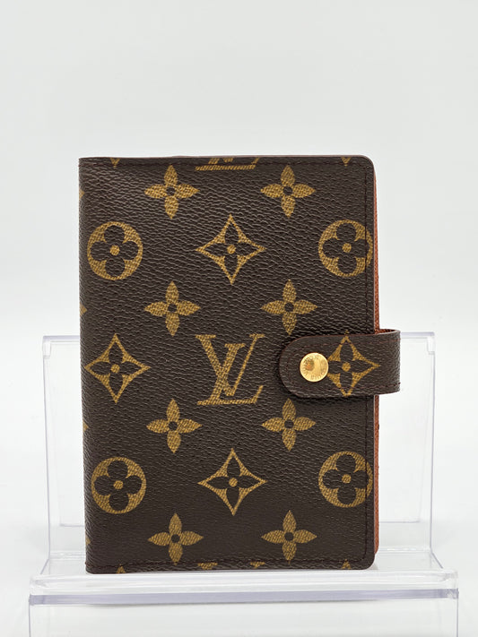 Louis Vuitton wallet with monogram pattern on a white background