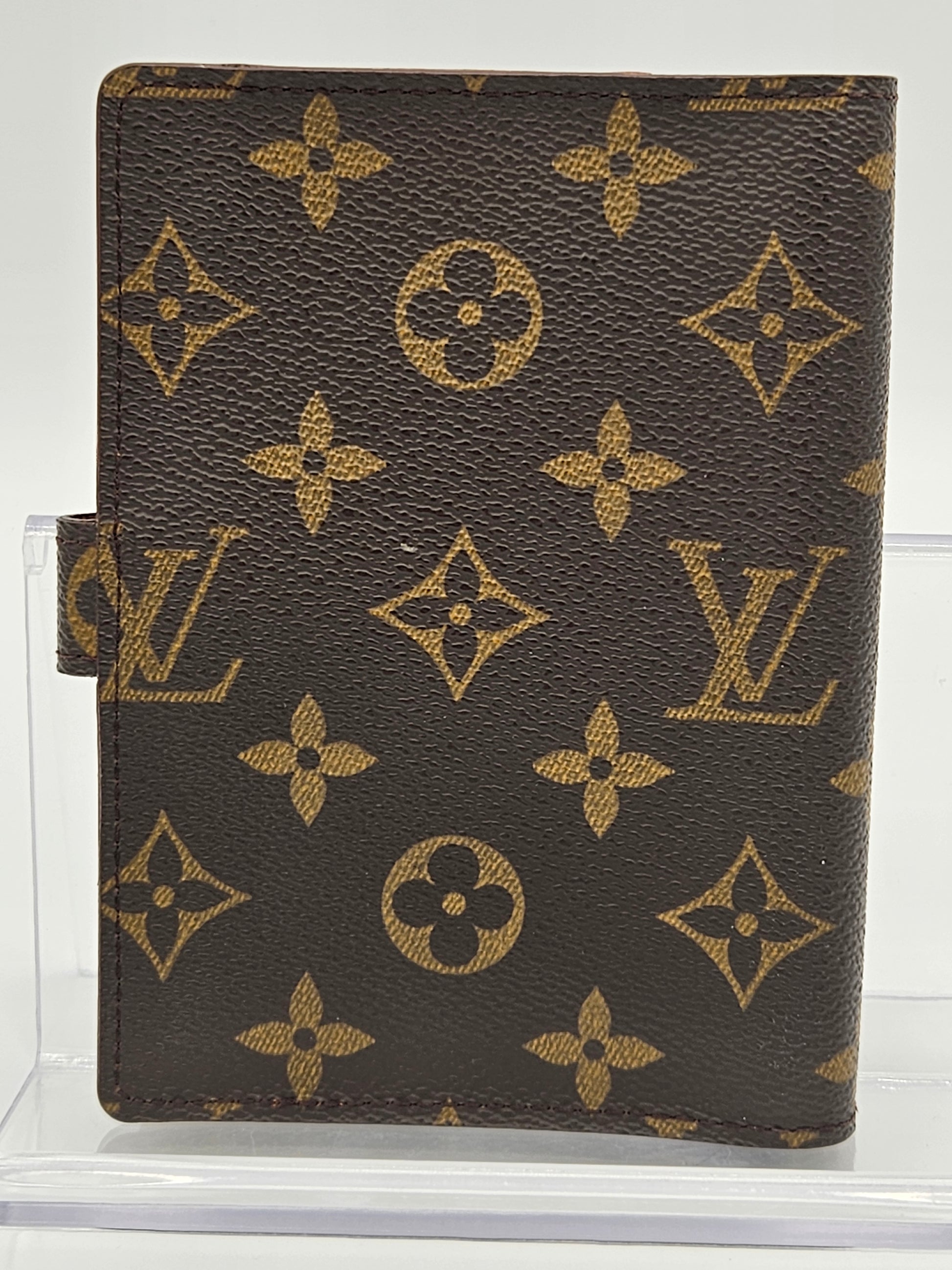Louis Vuitton wallet with monogram pattern on a white background