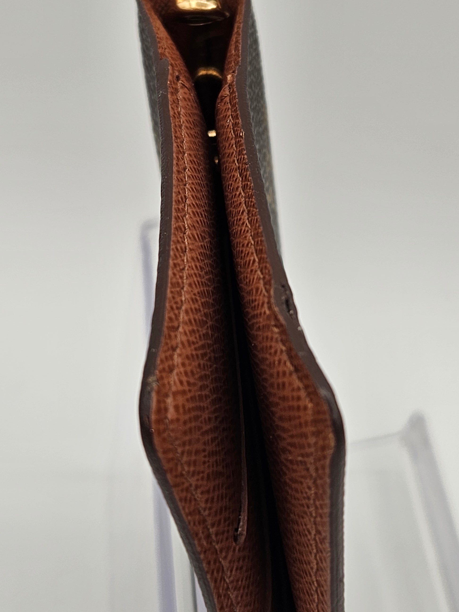 Close-up of a brown leather wallet on a light gray background