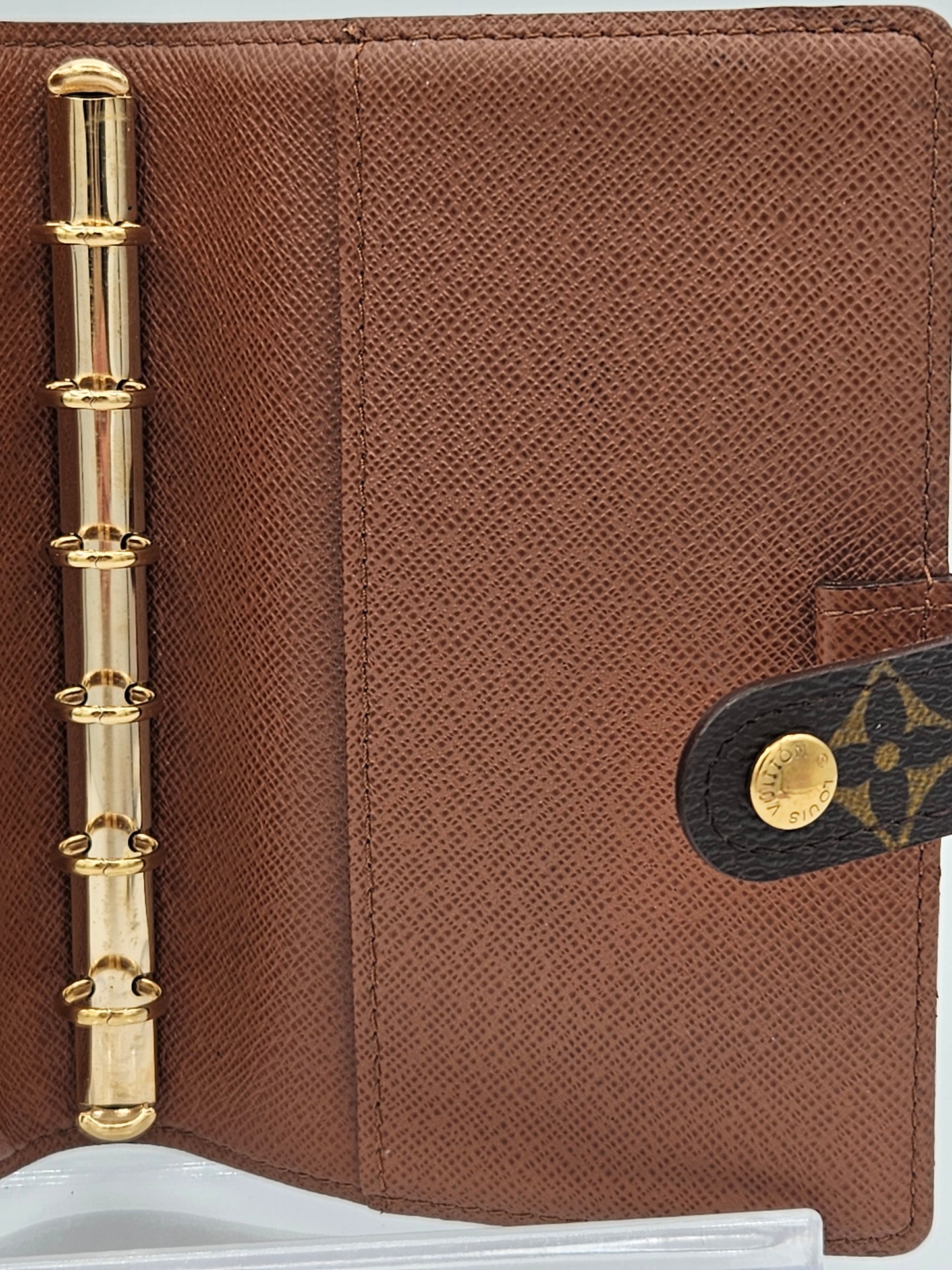 Brown leather planner with gold accents on a white background