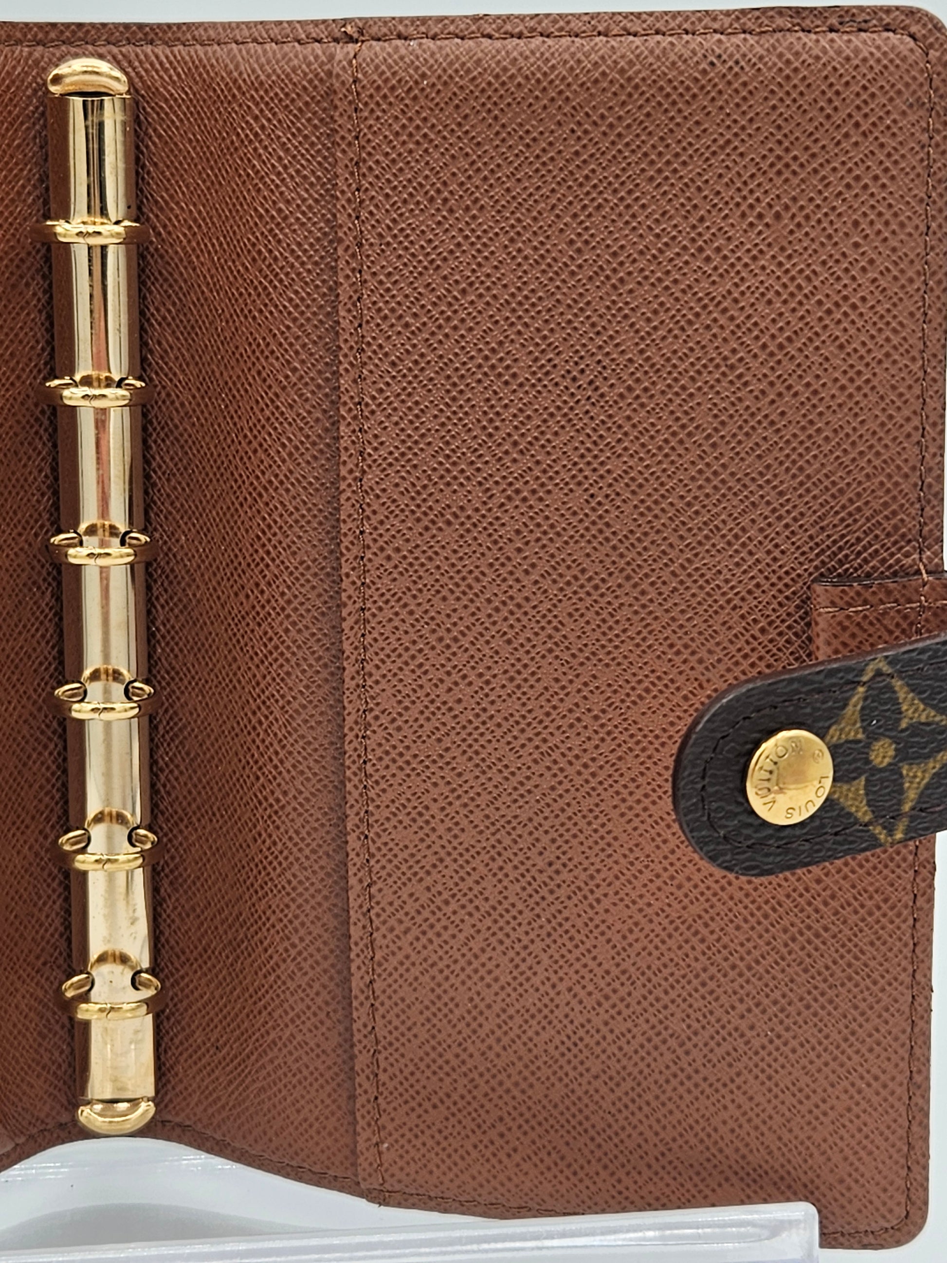 Brown leather planner with gold accents on a white background