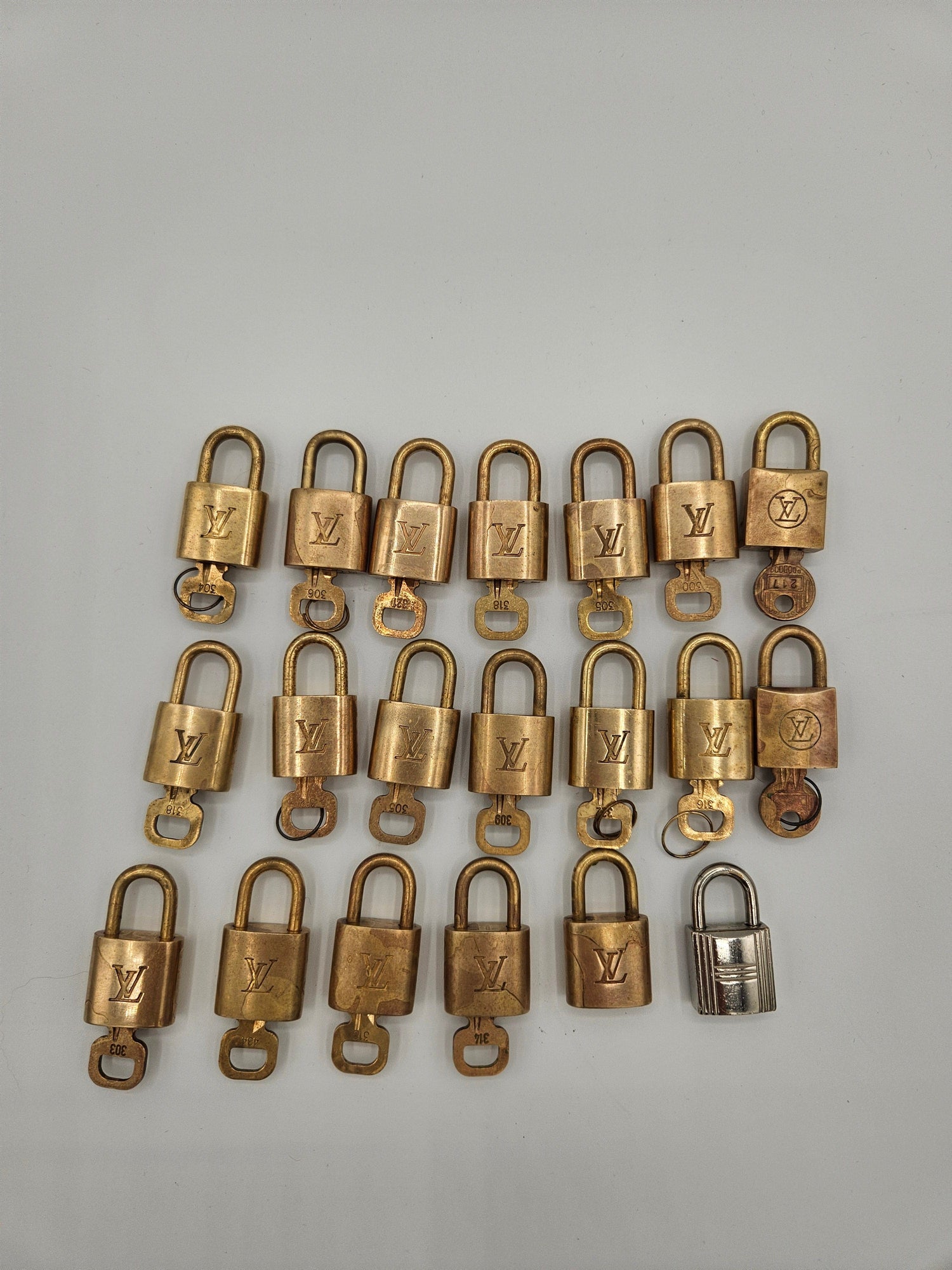 Multiple gold padlocks arranged in a grid on a light gray background