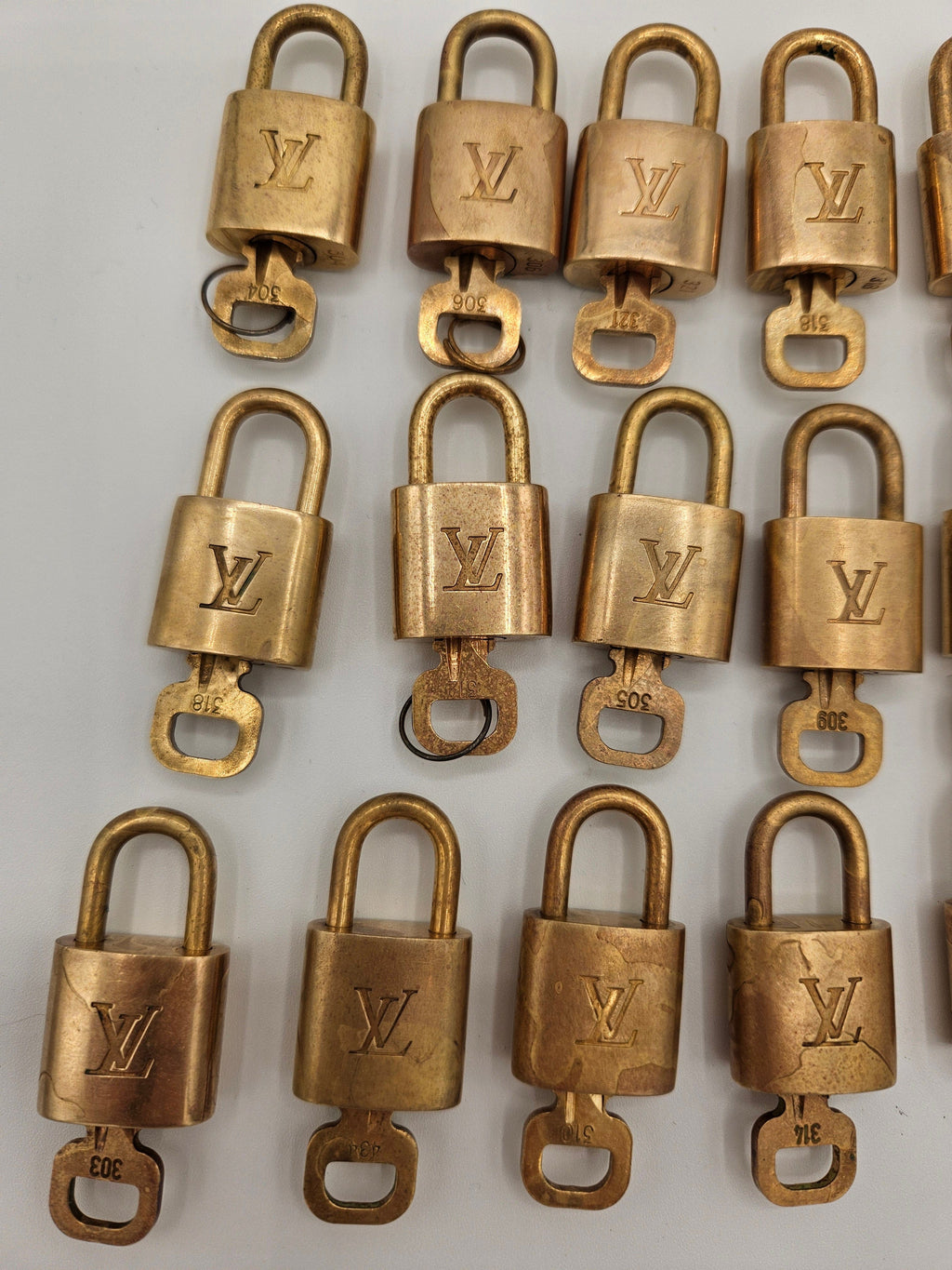 Multiple gold padlocks with a visible brand logo on a white background
