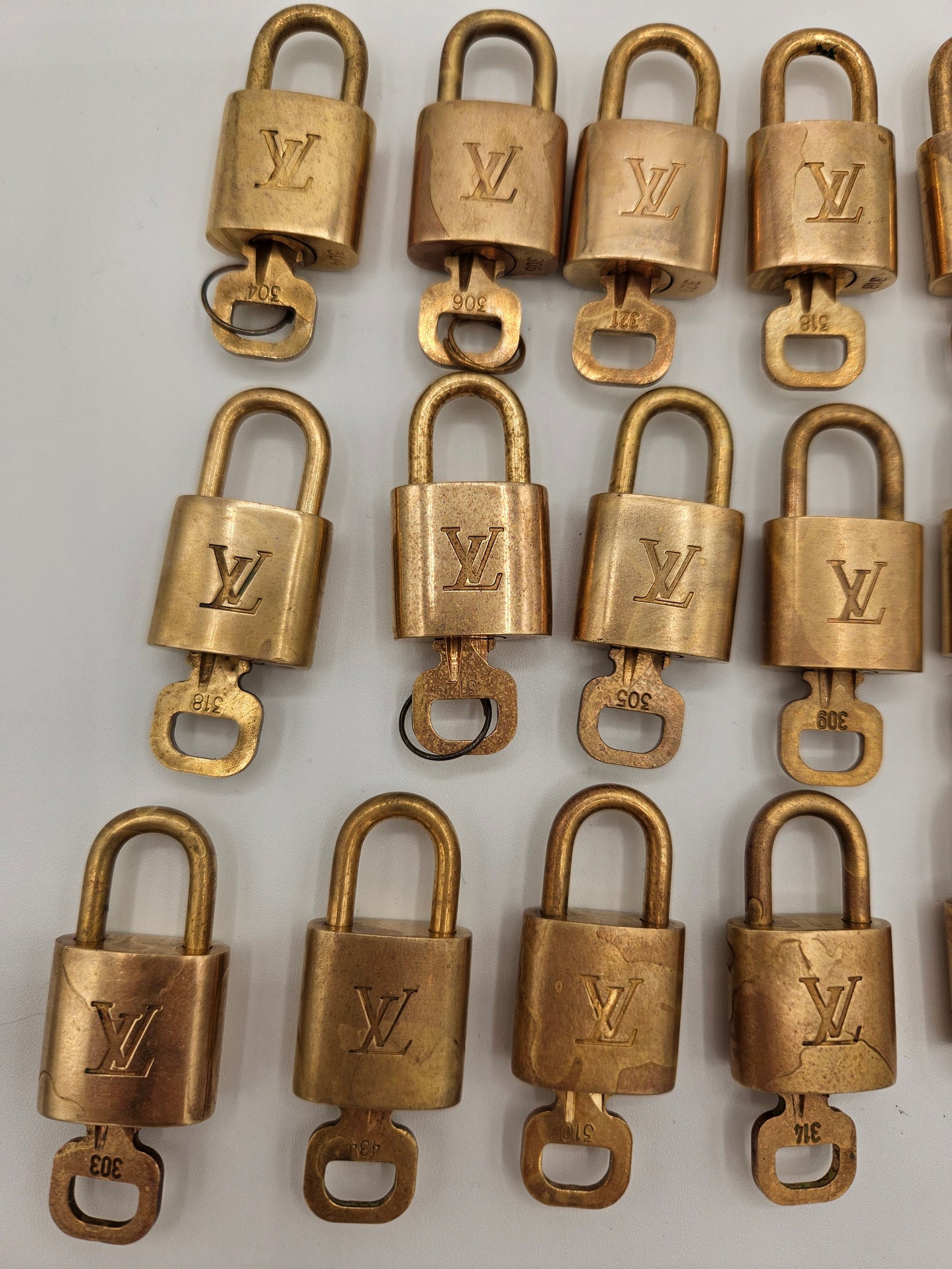 Multiple gold padlocks with a visible brand logo on a white background