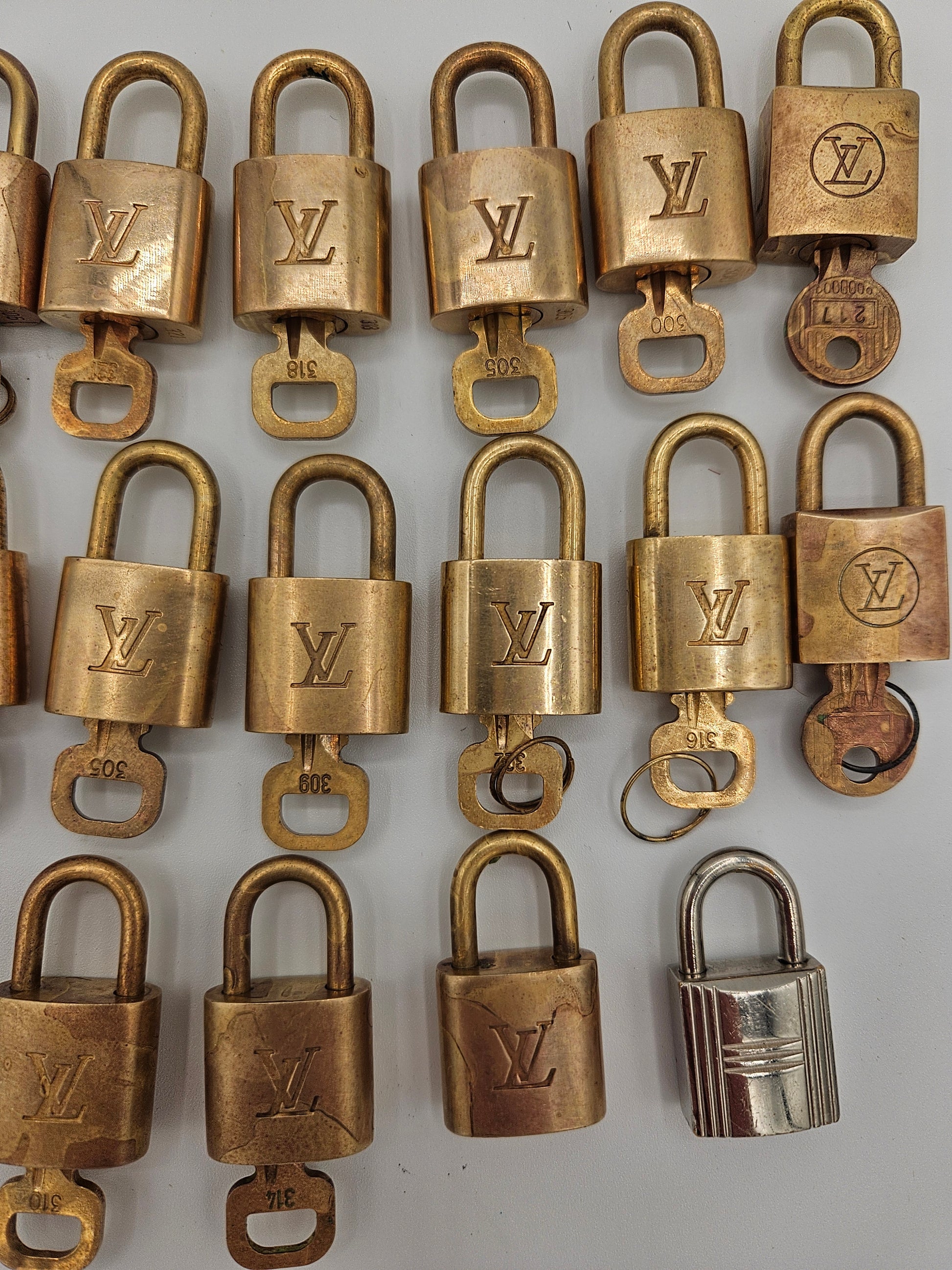 Collection of brass locks with a visible brand logo on a light gray background