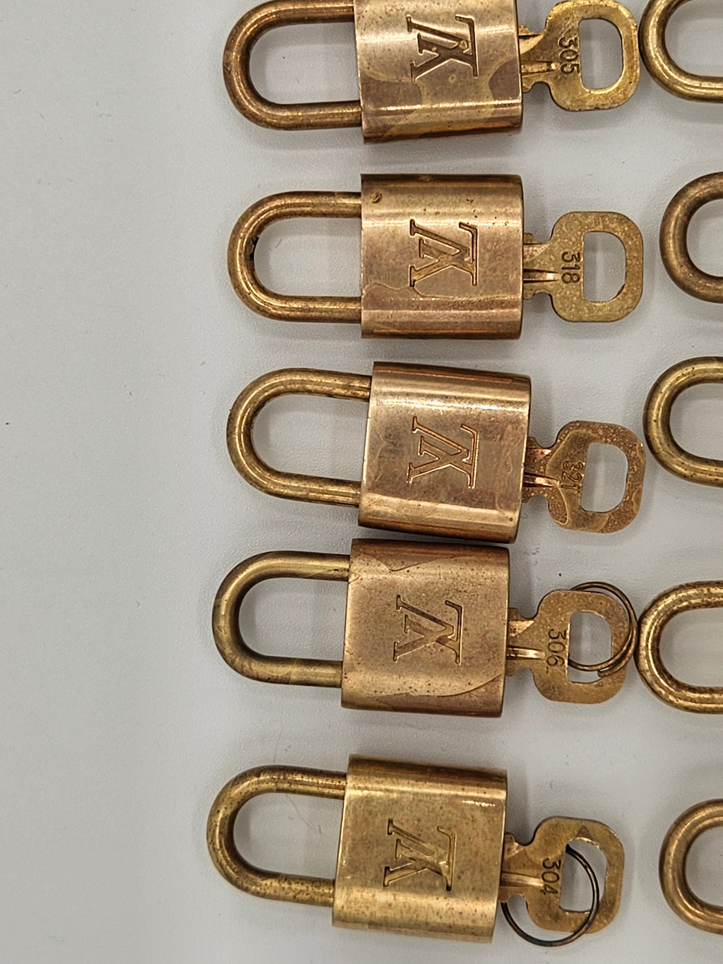 Row of brass locks with a visible brand logo on a white background