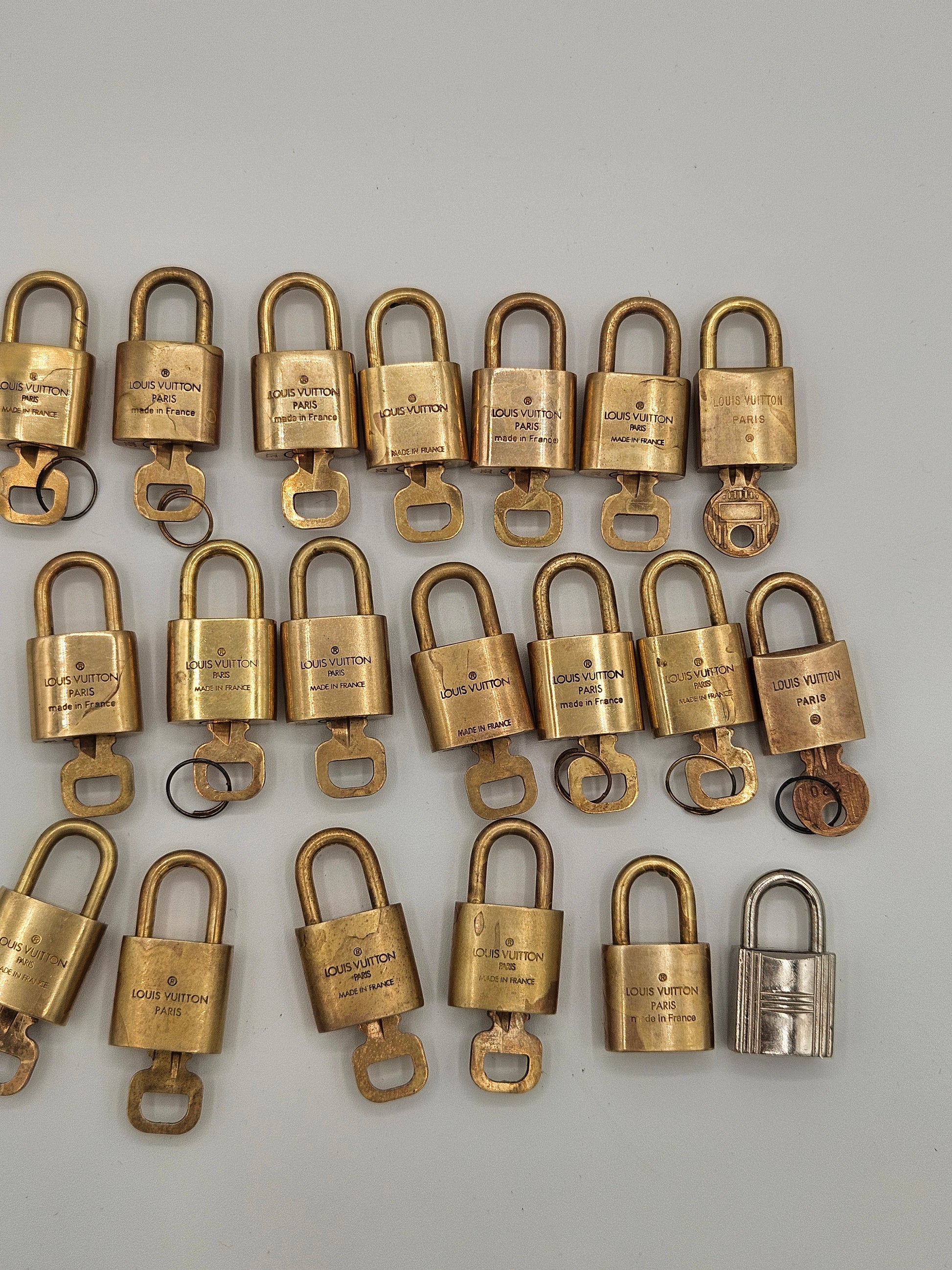 Multiple brass padlocks arranged in rows on a gray background