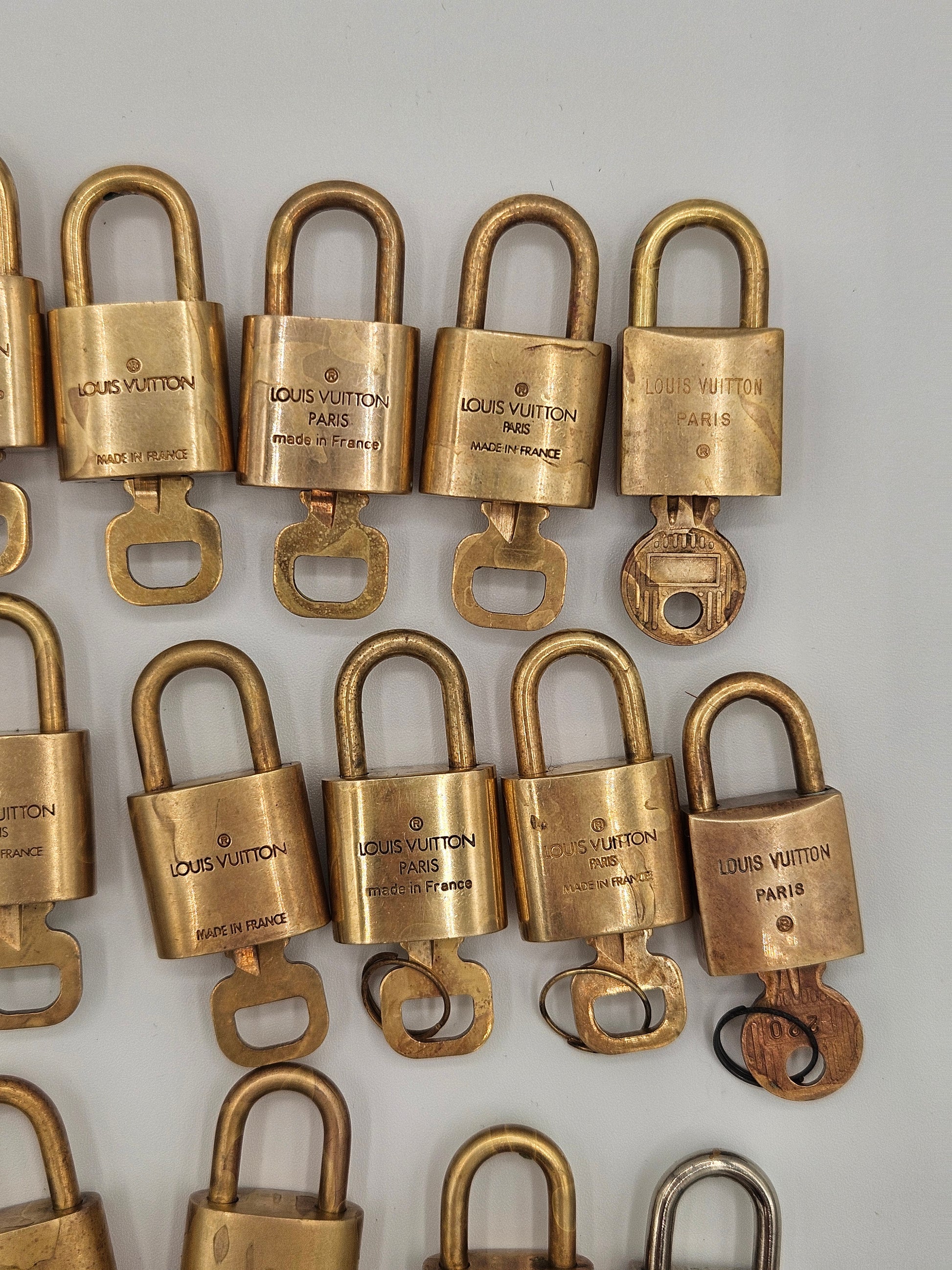 Multiple gold padlocks with visible brand name on a light gray background