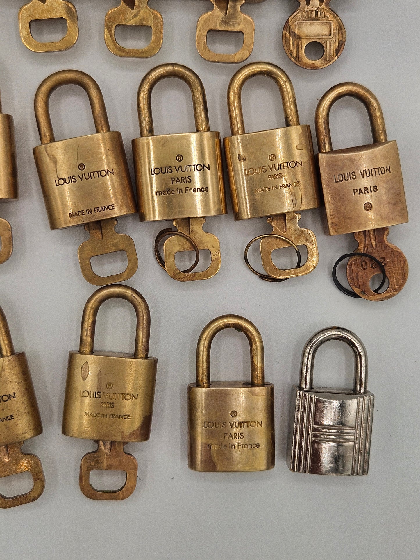 Collection of Louis Vuitton padlocks in various colors on a light gray background