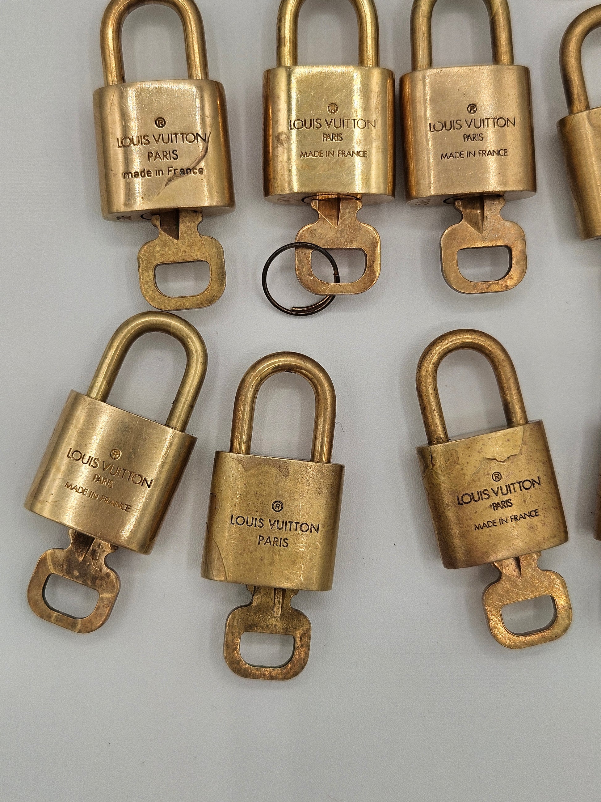 Gold Louis Vuitton padlocks on a white background