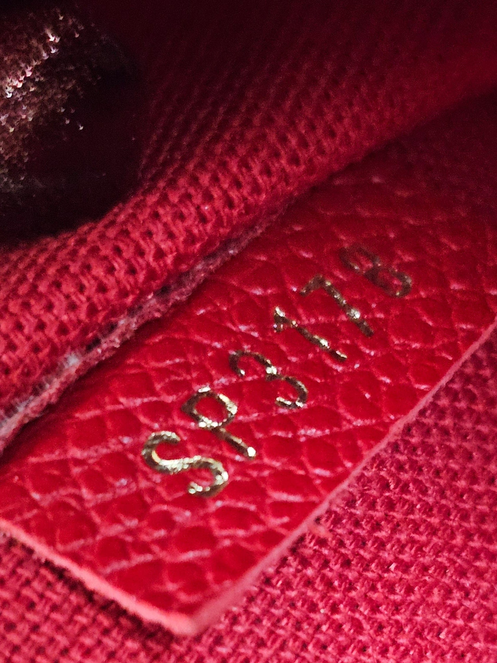 Close-up of a red fabric with a brand logo on a blurred background