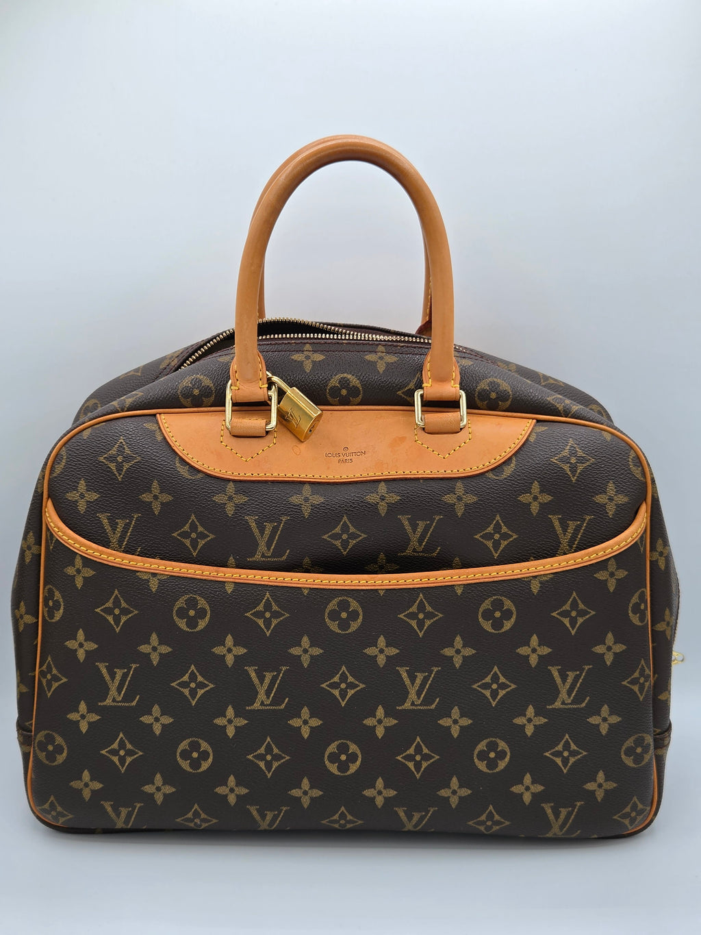 Designer handbag with monogram pattern on a light gray background