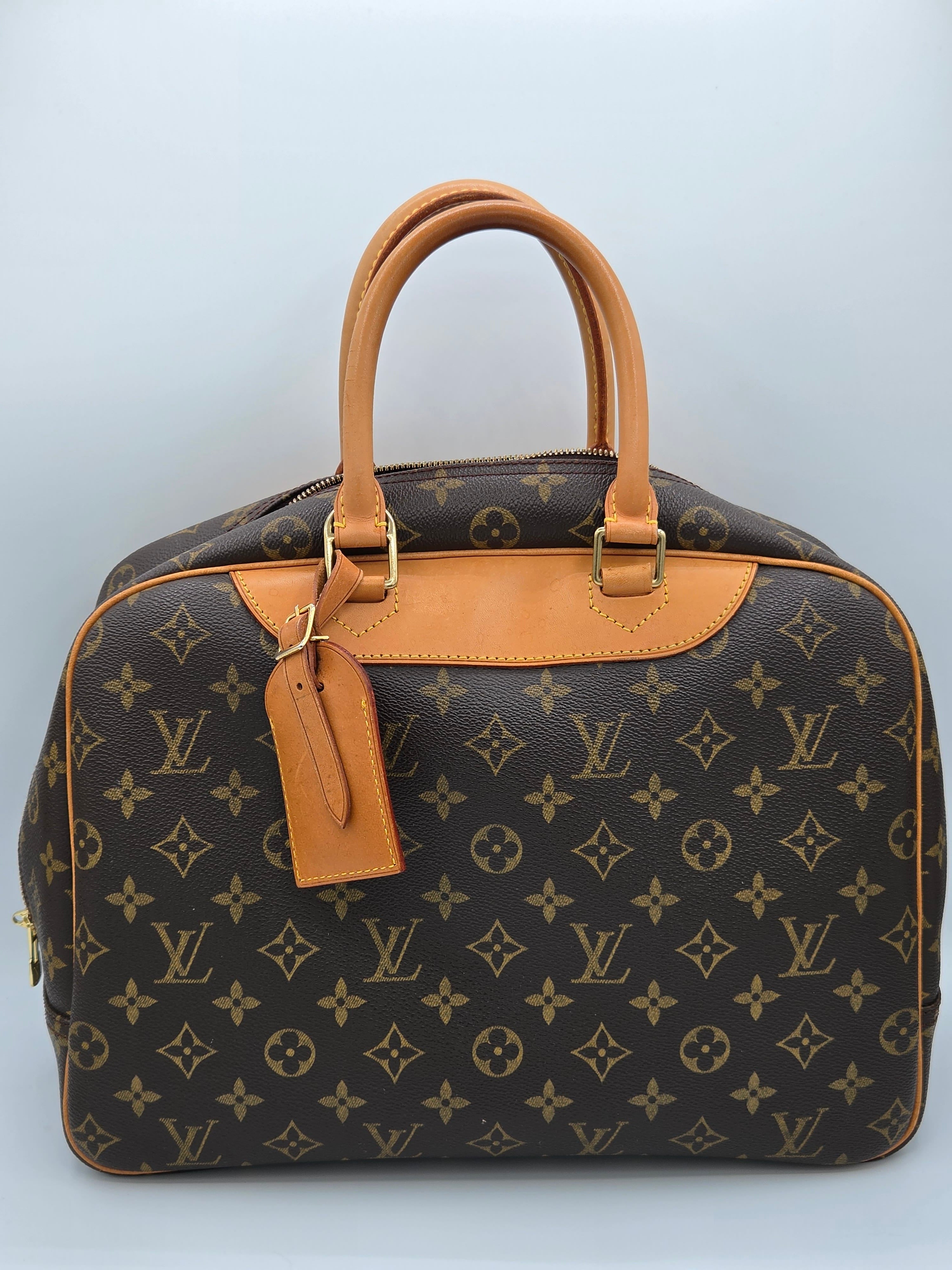 Designer handbag with monogram pattern on a light gray background