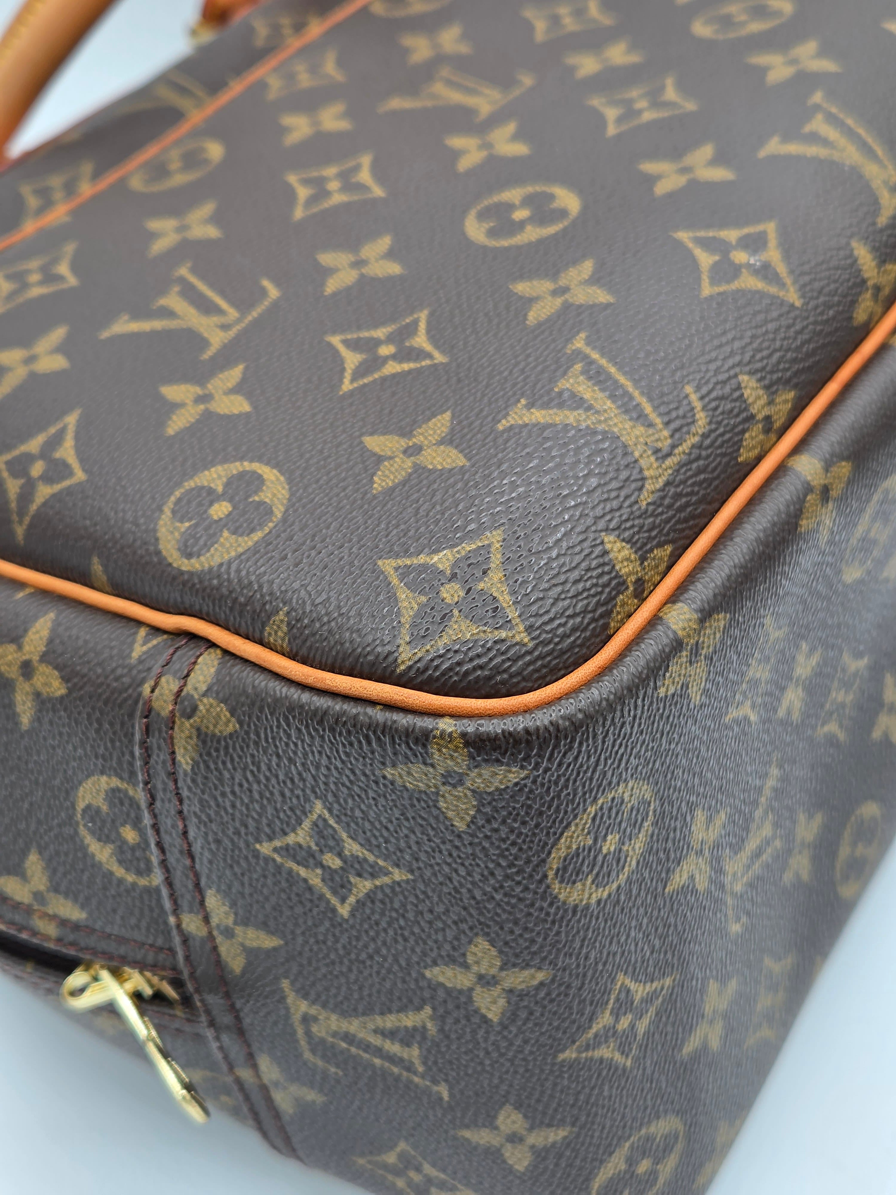 Close-up of a brown leather bag with gold monogram pattern