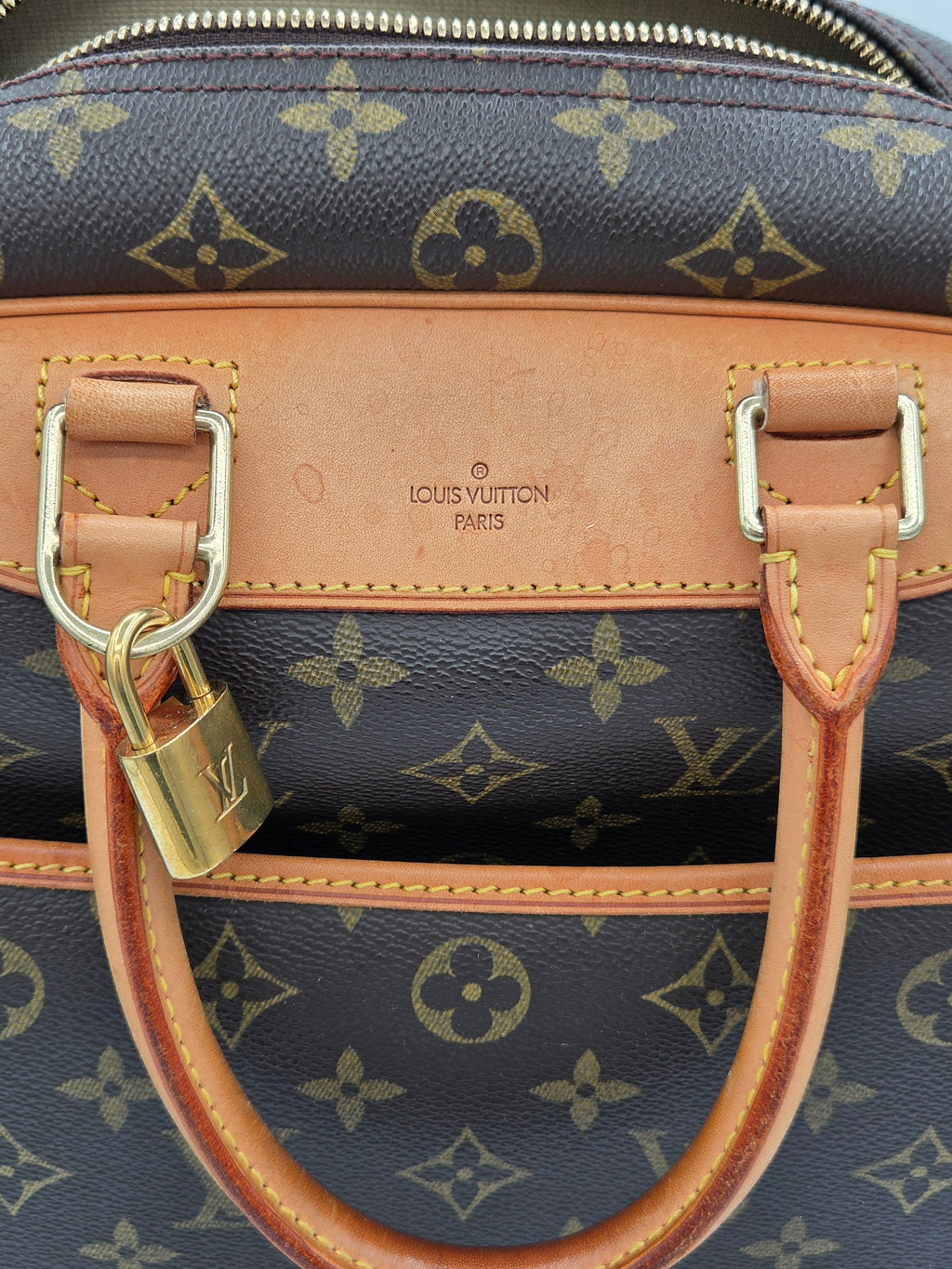 Close-up of a Louis Vuitton handbag with monogram pattern and visible brand logo.