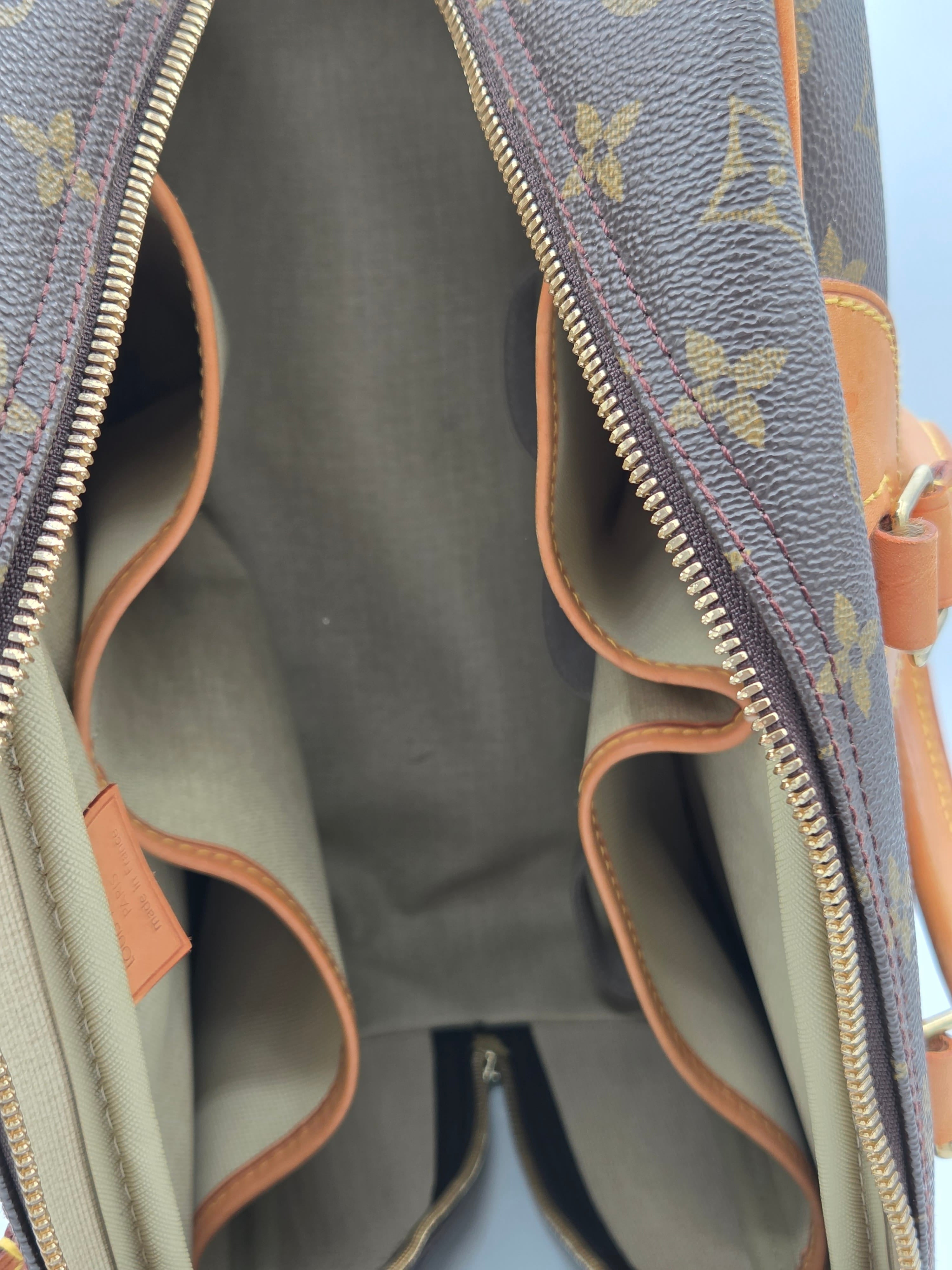 Close-up of a gray handbag with brown leather accents and a visible brand logo.
