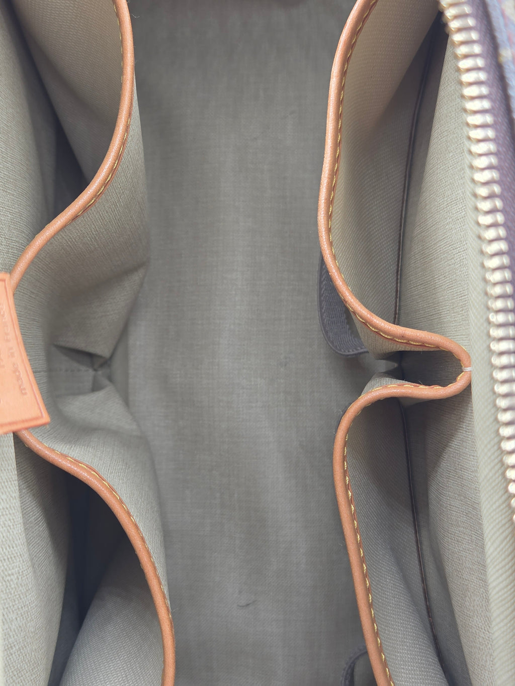 Gray bag with brown leather trim and zipper