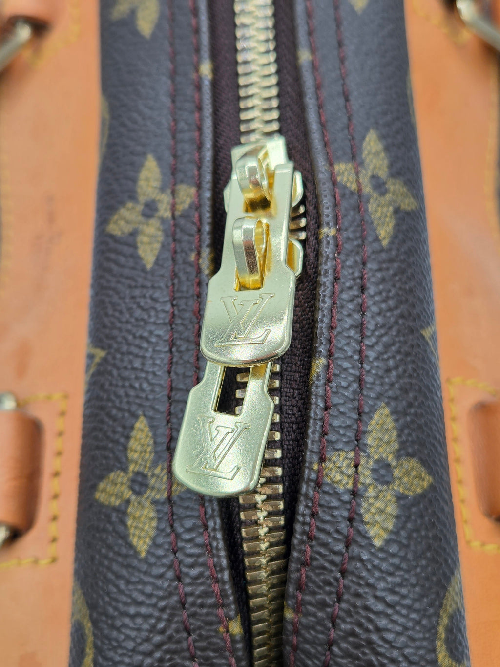 Close-up of a zipper on a Louis Vuitton monogram bag
