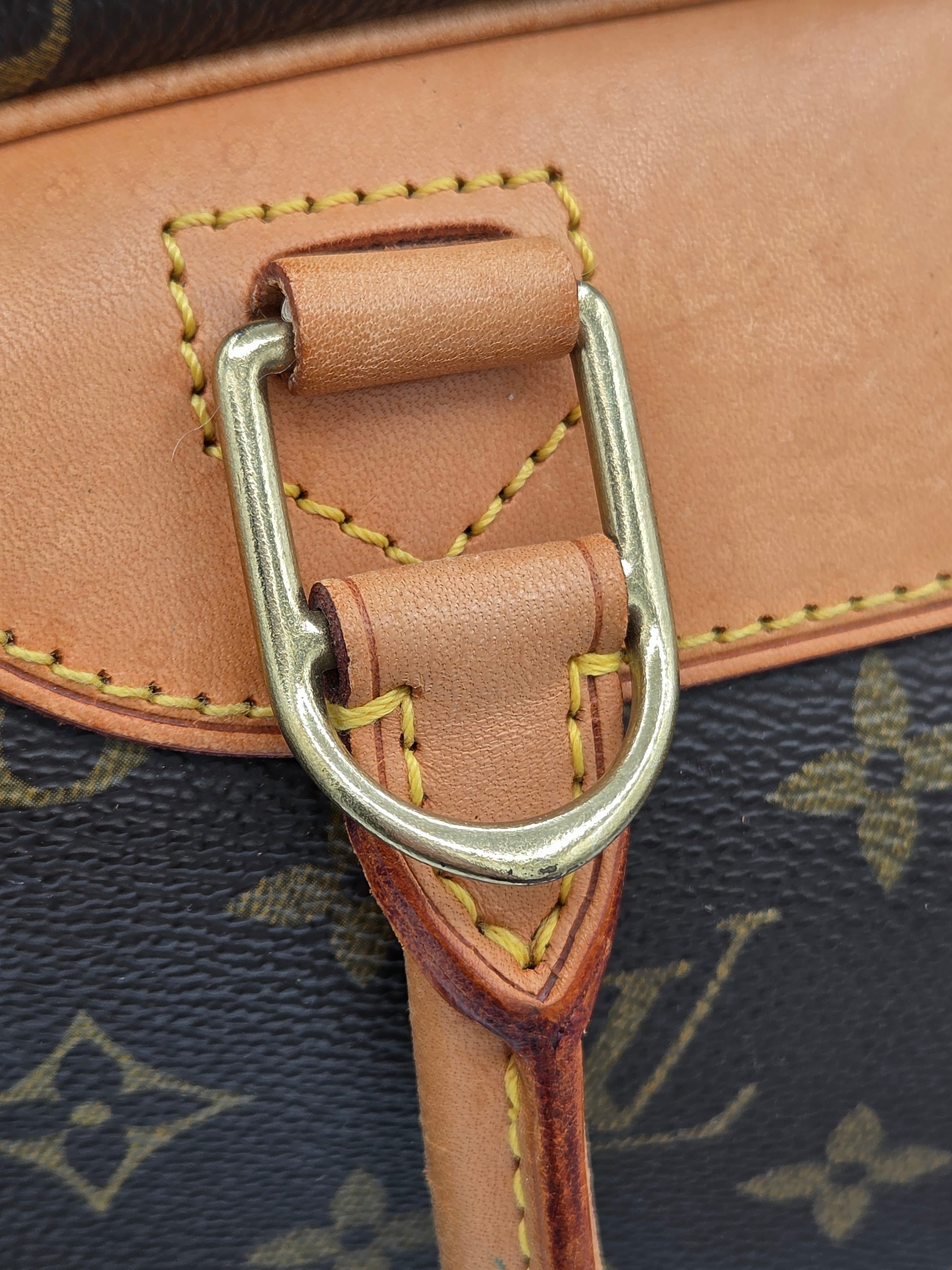 Close-up of a brown leather strap with a silver buckle on a patterned background