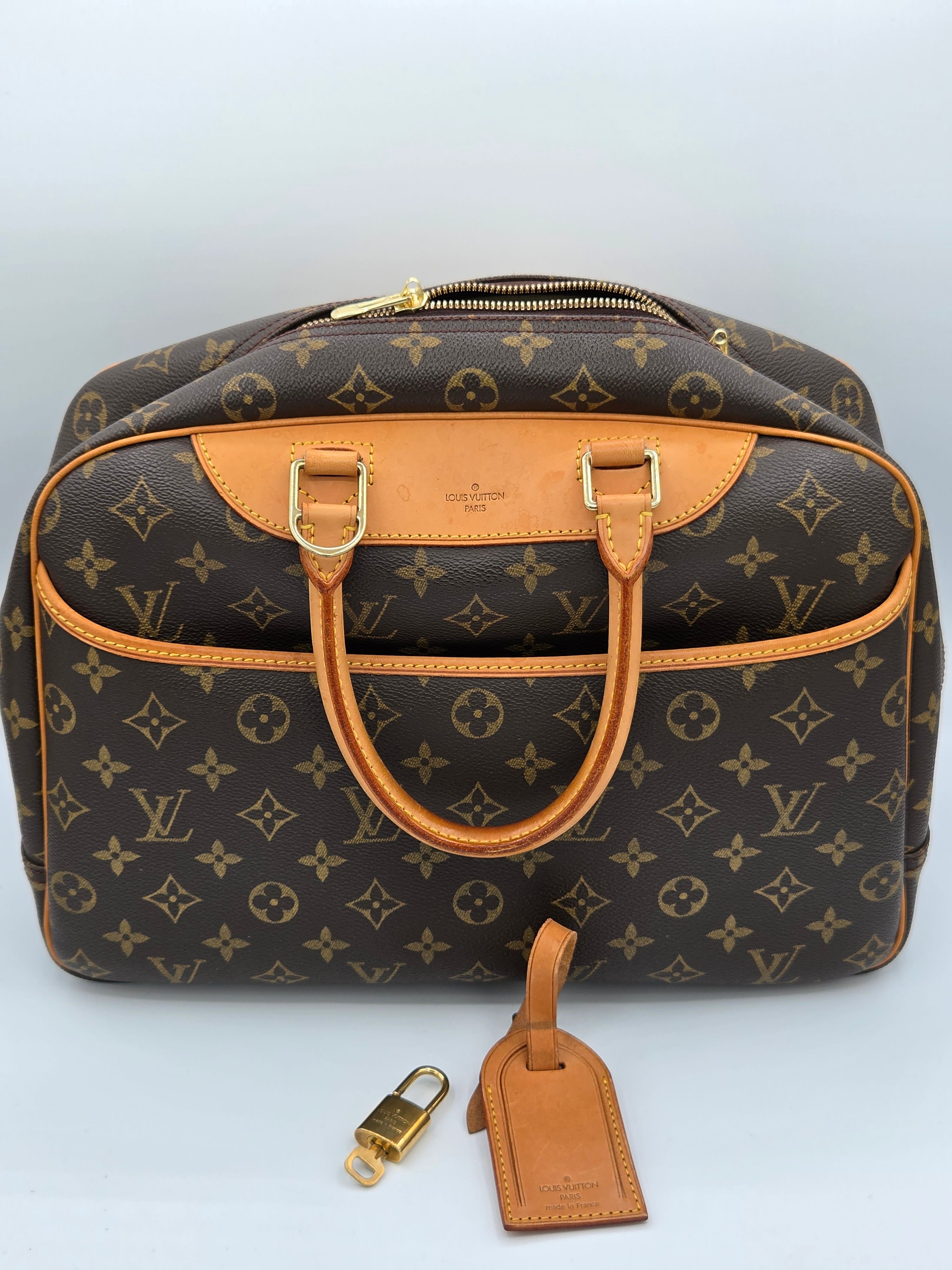 Designer handbag with monogram pattern on a light gray background