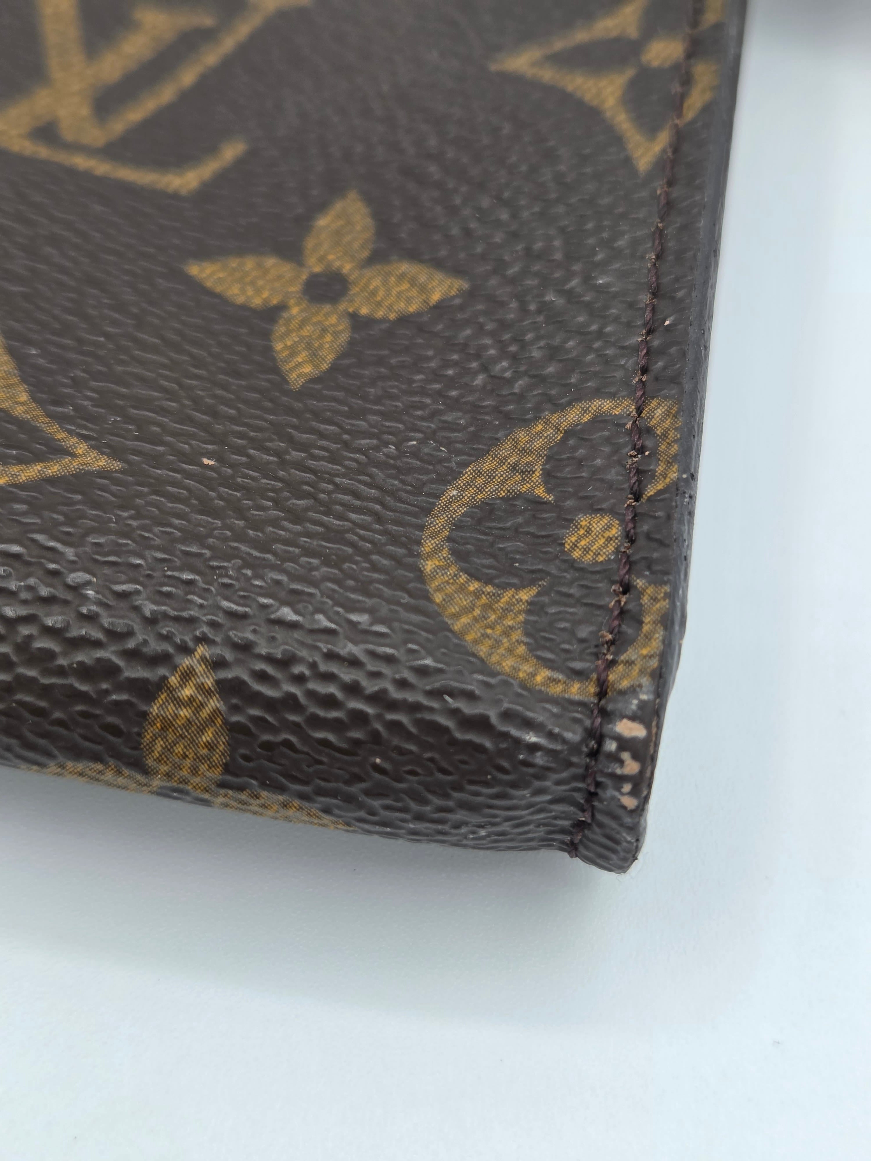 Close-up of a Louis Vuitton wallet with monogram pattern on a white background