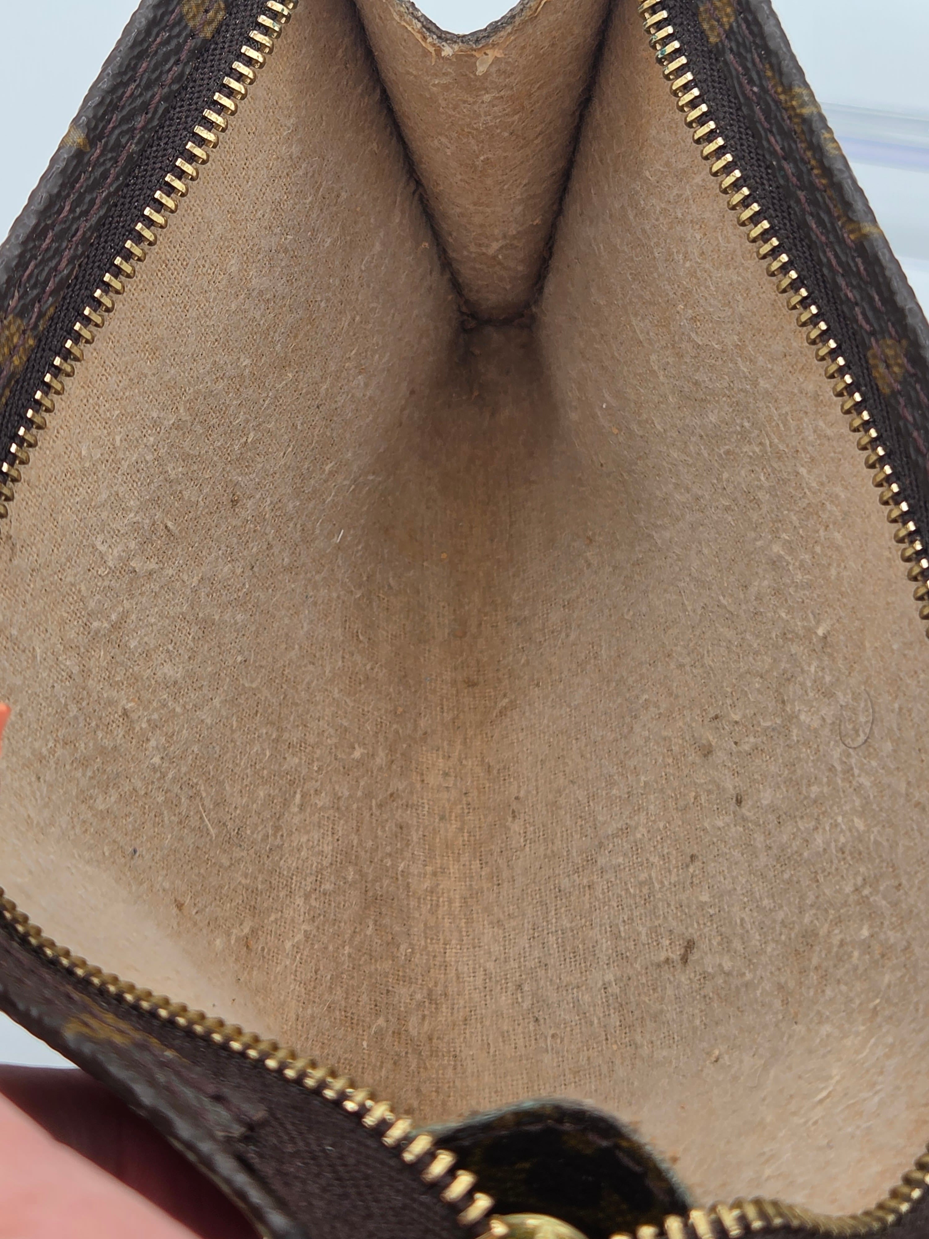 Close-up of a brown leather wallet with gold zipper