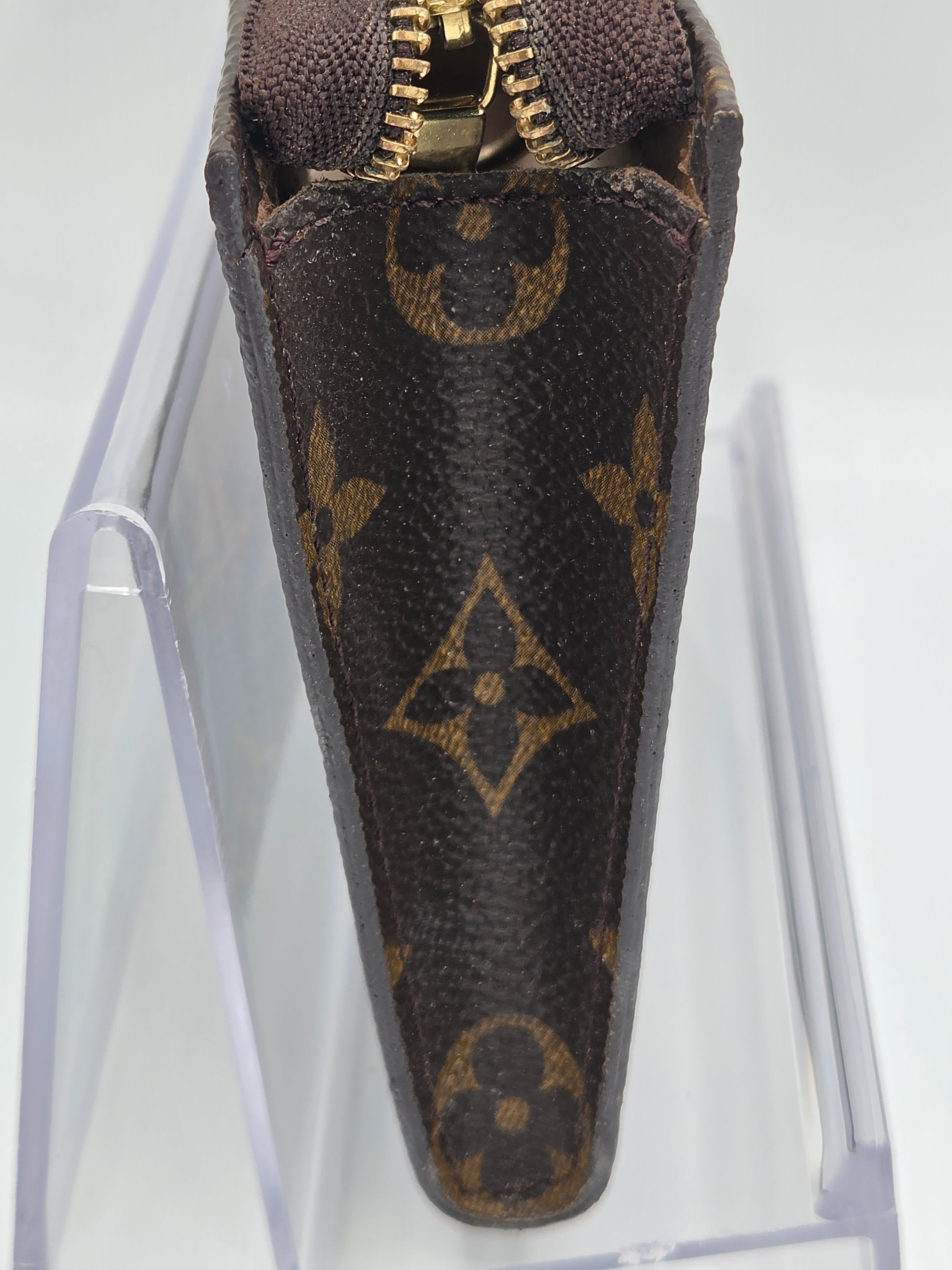Louis Vuitton monogram clutch bag on a clear stand