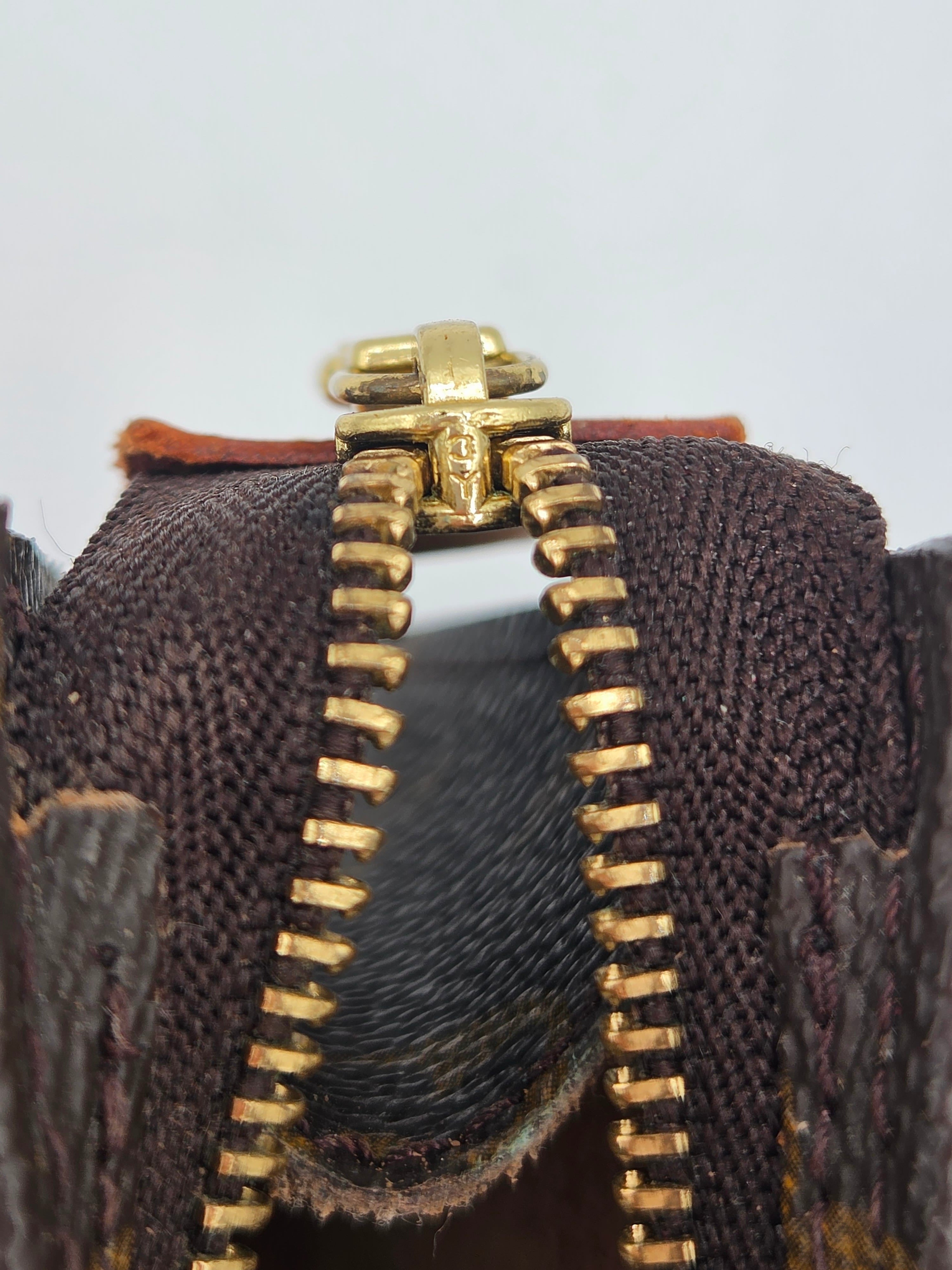 Close-up of a gold zipper on a brown textured fabric background