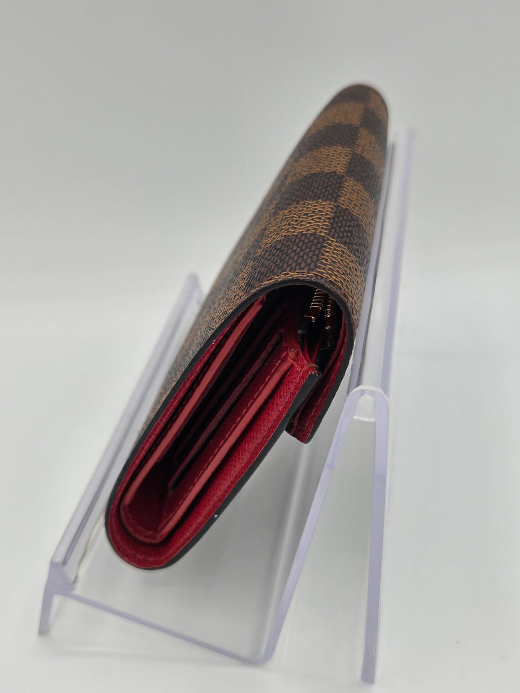 Designer wallet with brown and gold pattern on a white background