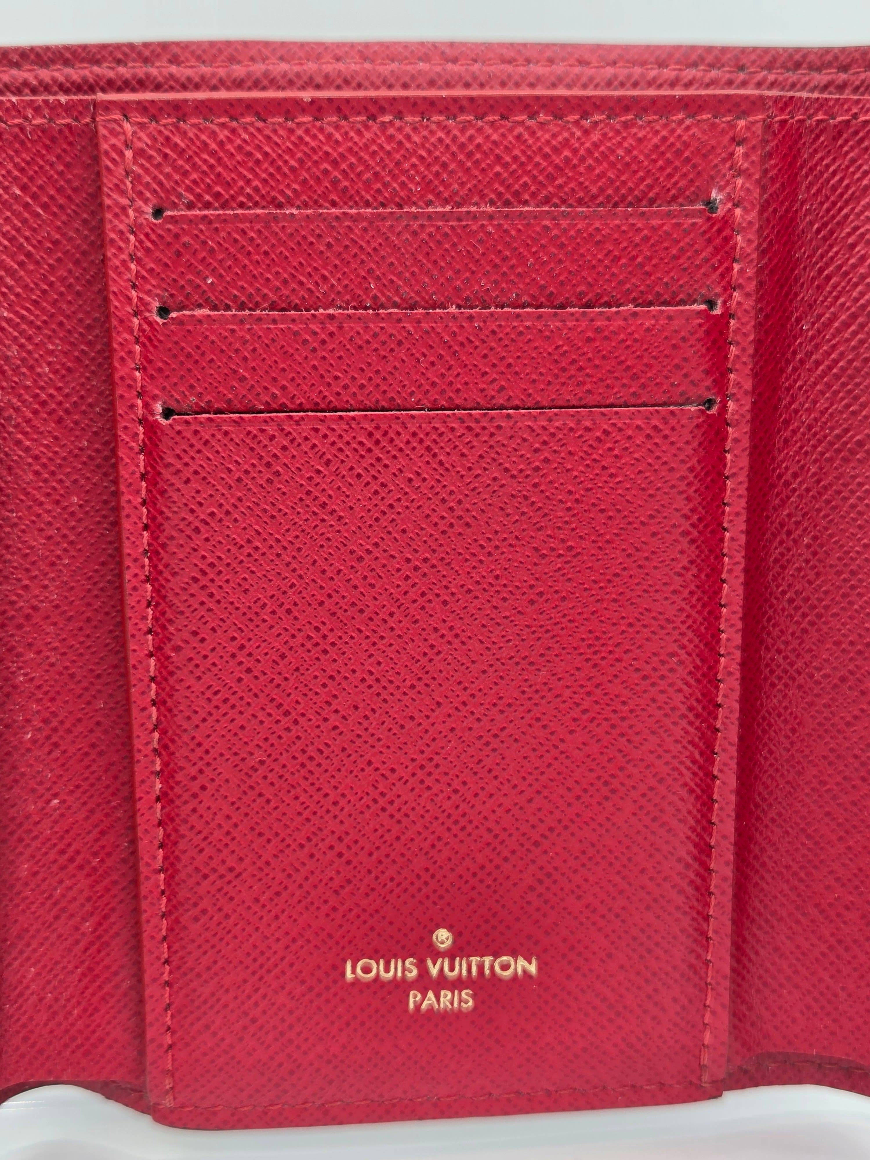 Close-up of a red Louis Vuitton wallet with visible branding.