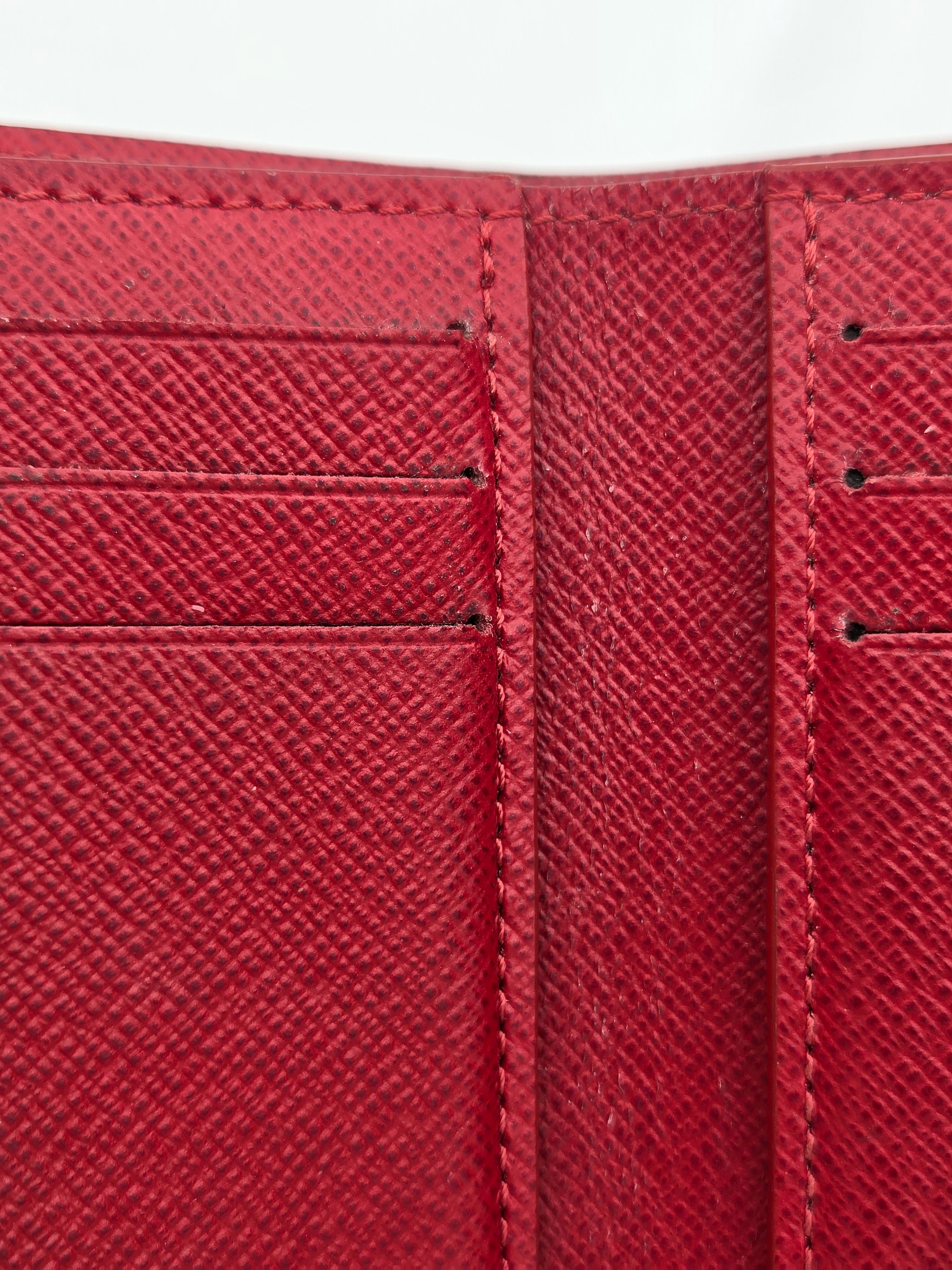 Close-up of a red textured wallet with stitching details on a white background