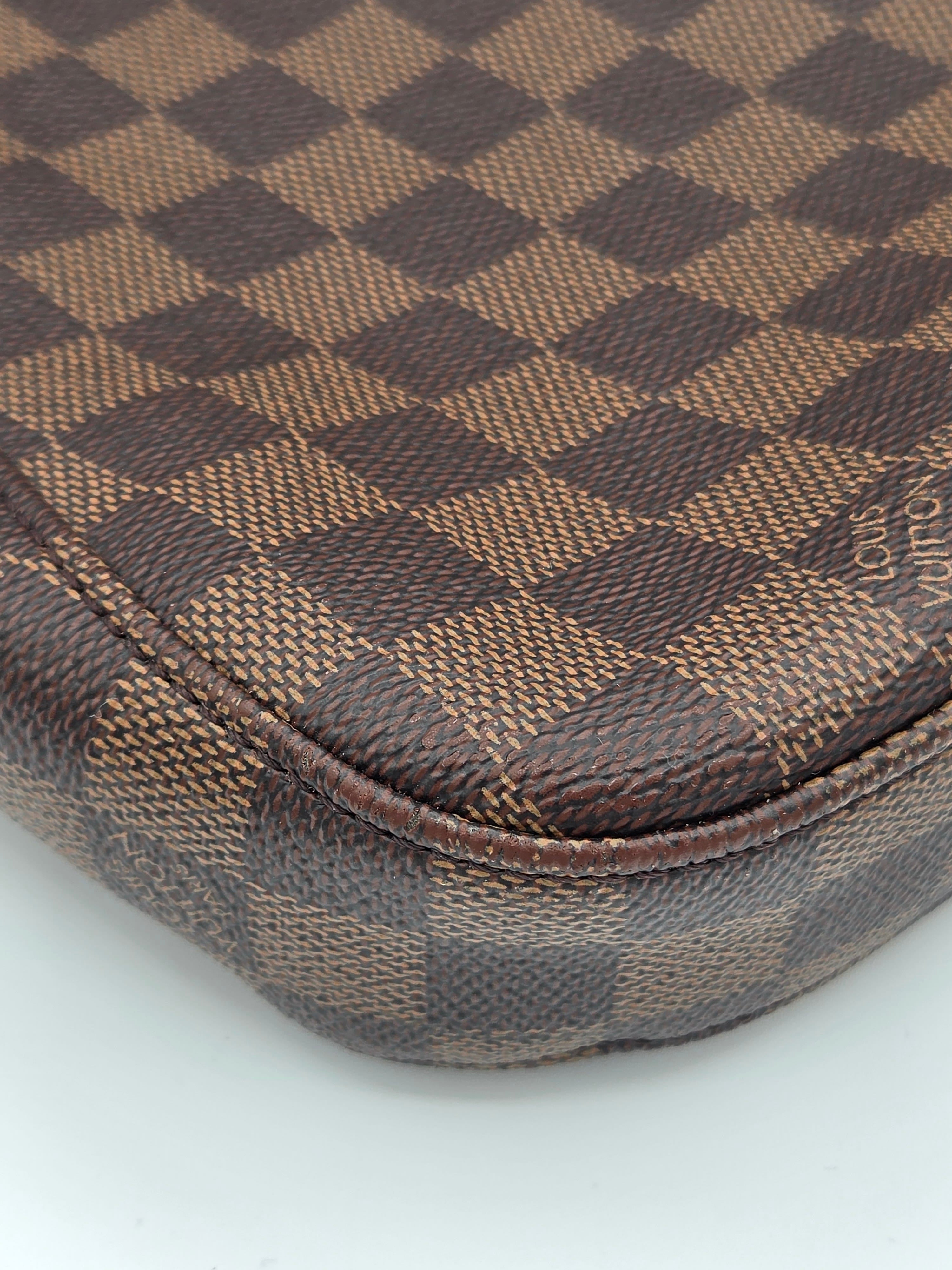 Close-up of a brown and beige checkered fabric with a brand logo on a white background