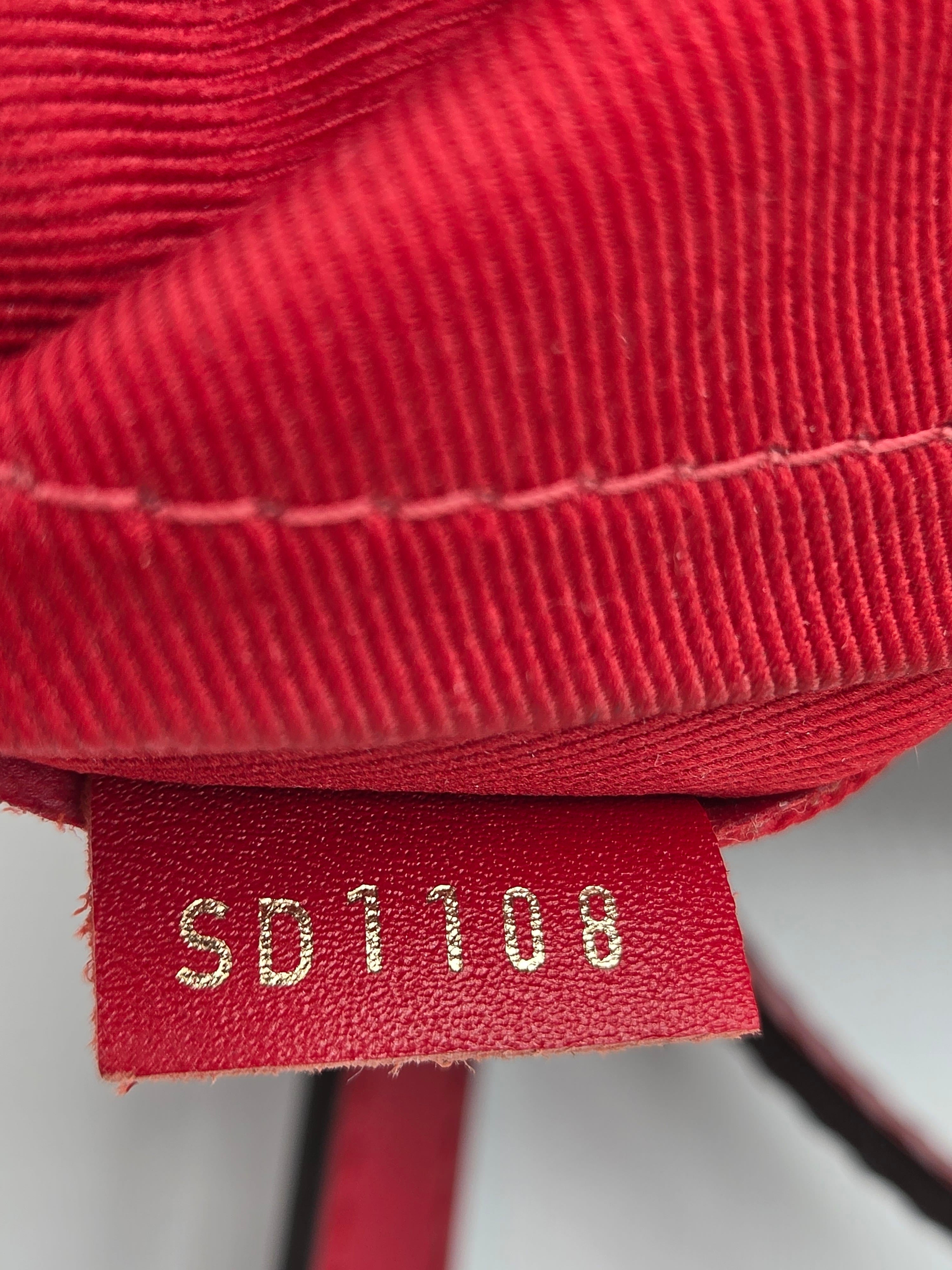 Close-up of a red textured fabric with a brand label on a white background