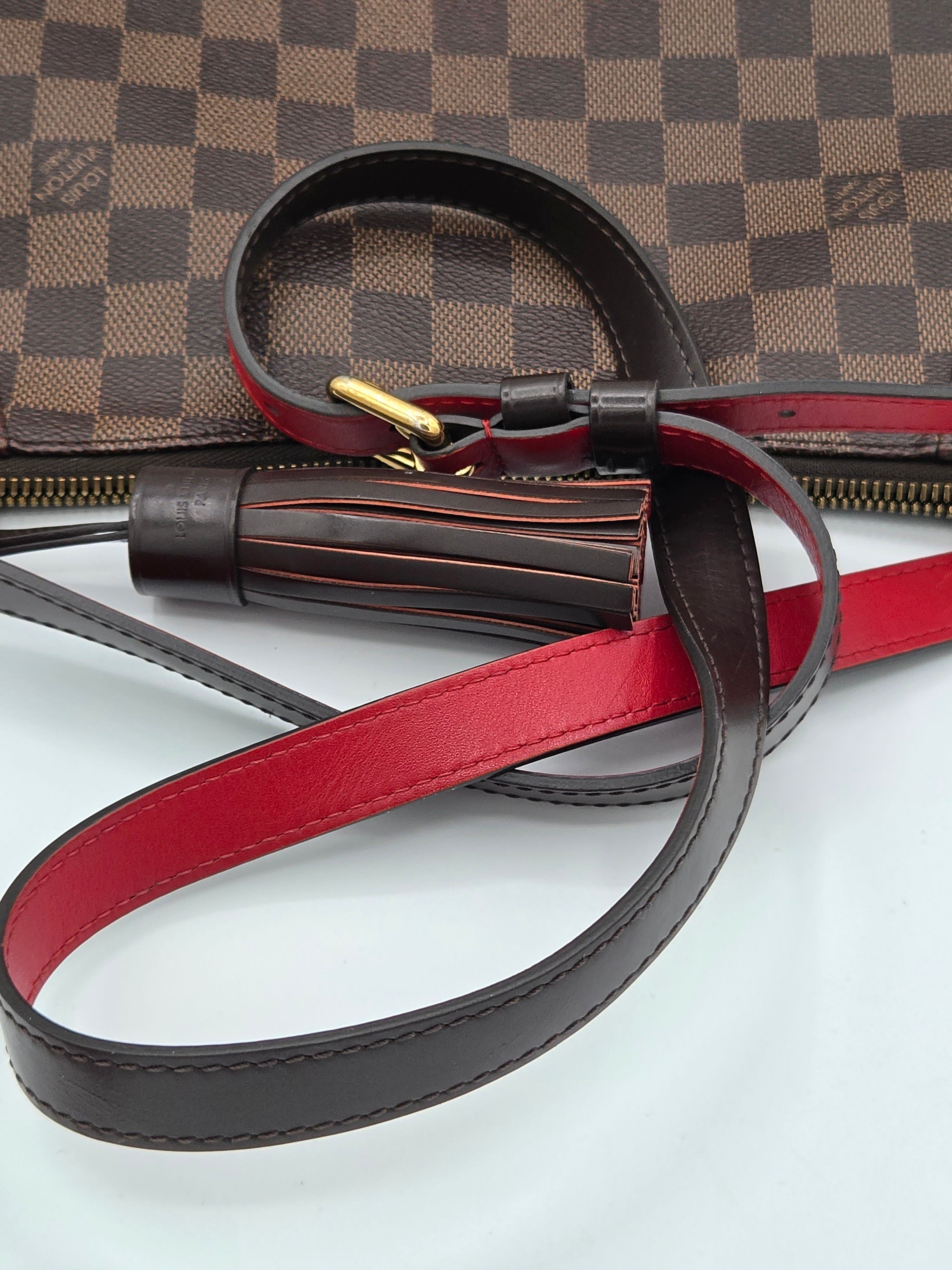 Close-up of a brown leather strap with gold hardware on a checkered surface
