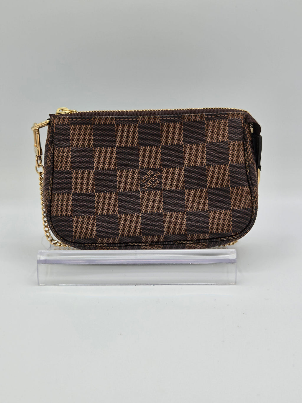 Checkered wallet with gold zipper on a light gray background