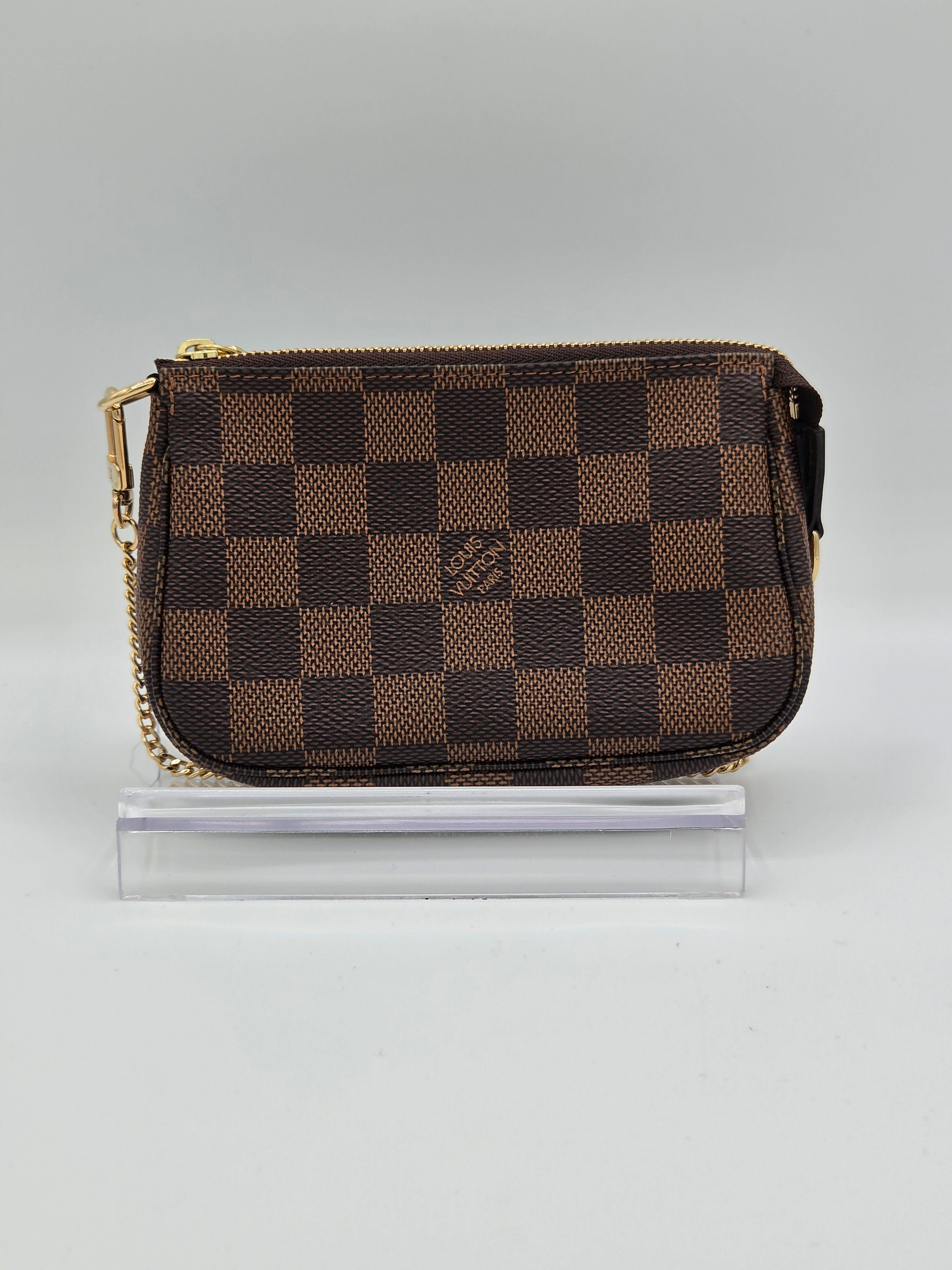 Checkered wallet with gold zipper on a light gray background