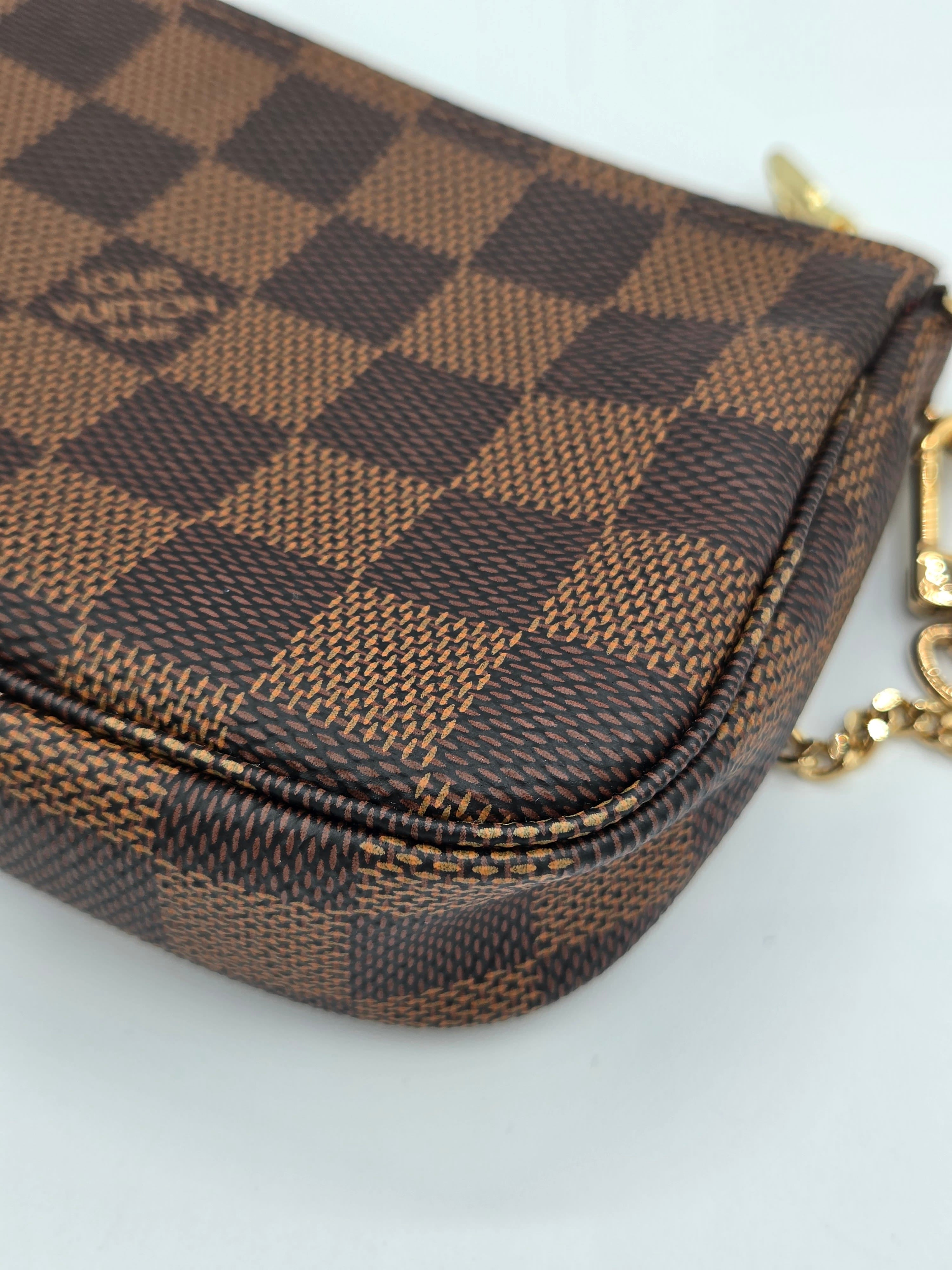 Brown checkered pouch with gold chain on a white background