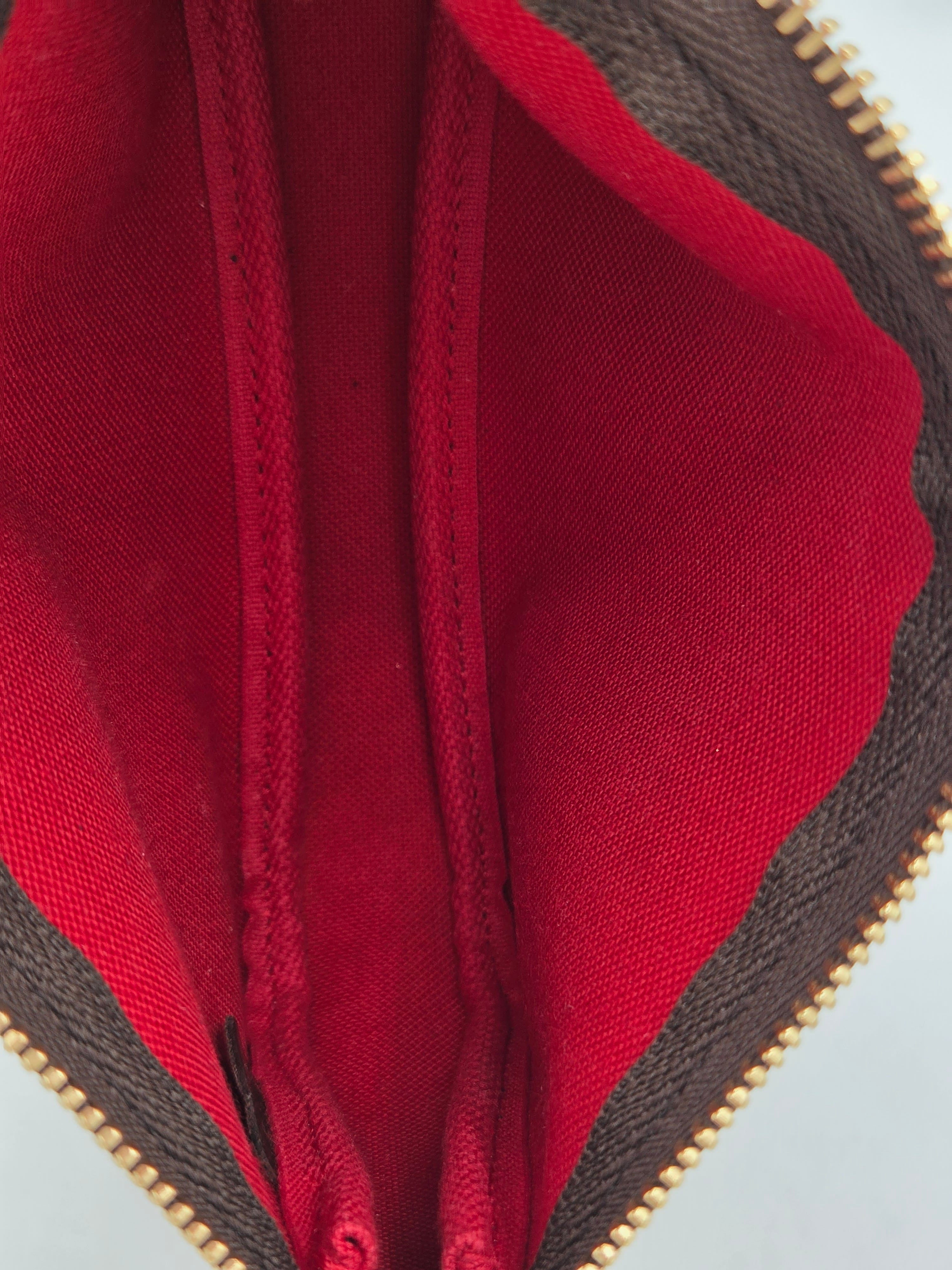 Close-up of a red fabric interior with a zipper, showing texture and stitching details.