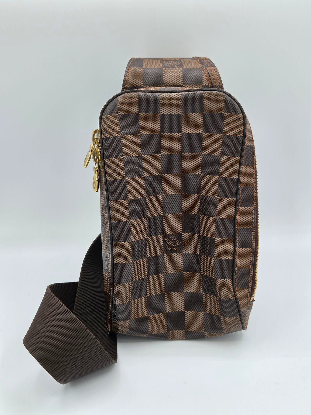 Brown checkered handbag with a strap on a light gray background